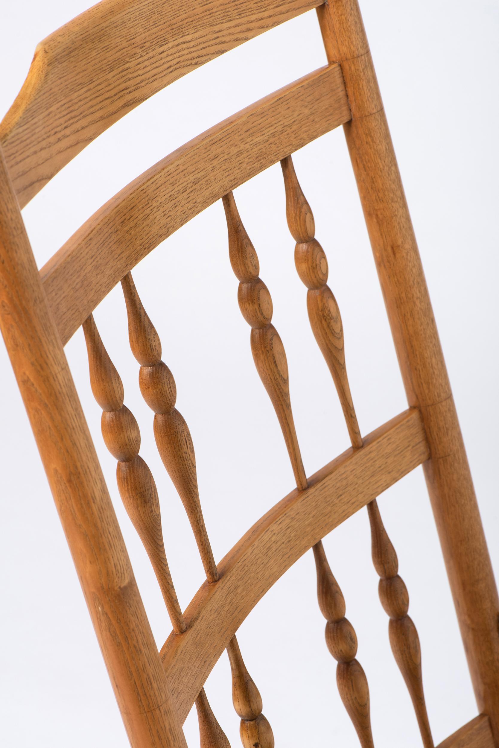 Oak Spindle back Rocking Chair with rush seat by Neville Neal, England circa 1920. For Sale