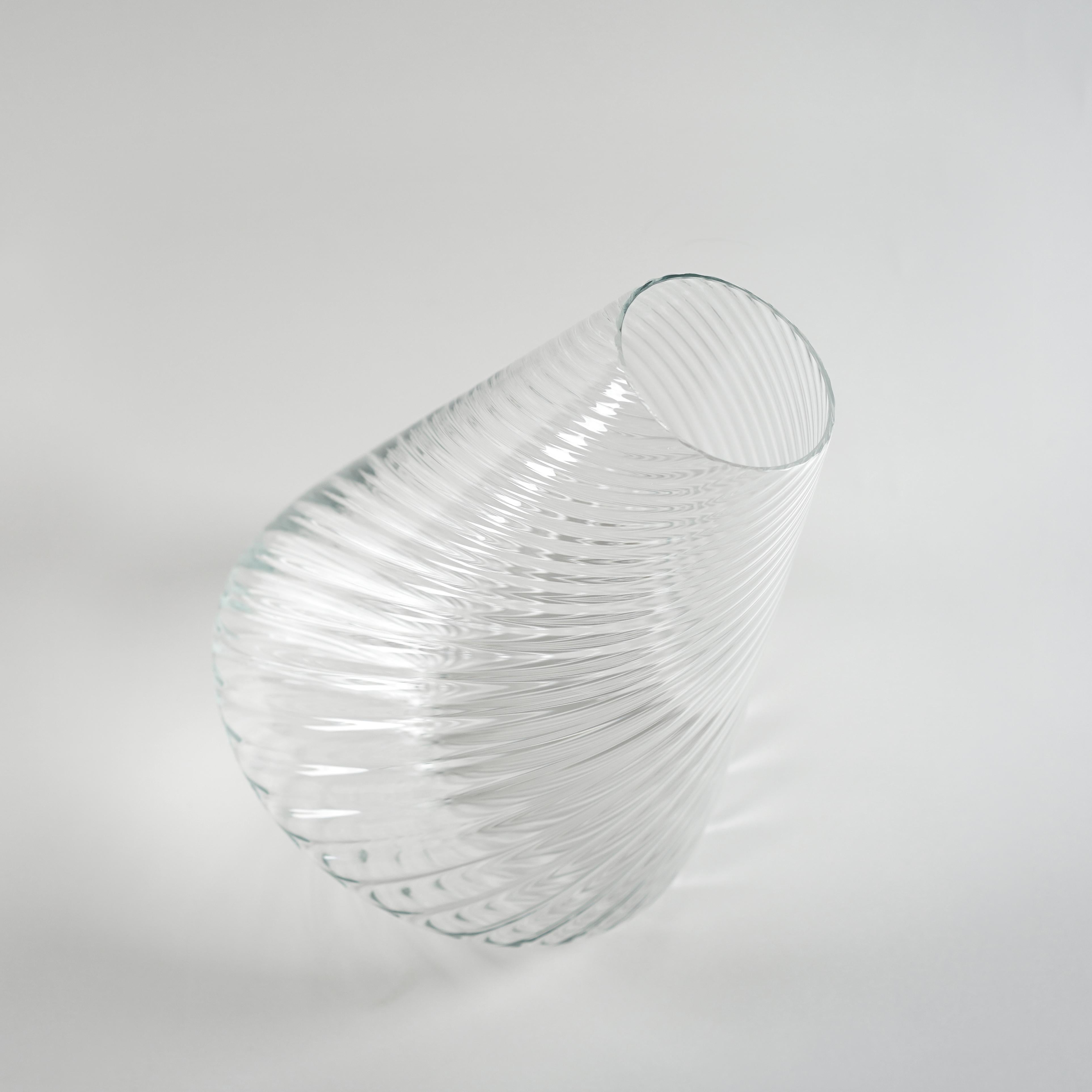 Who says a glass vase has to be static? That was the question that led me to create the spindle wheel glass vase.
The concept was movement. I wanted that a still piece like a vase could suggest the idea of motion, of spinning. 
The spindle wheel