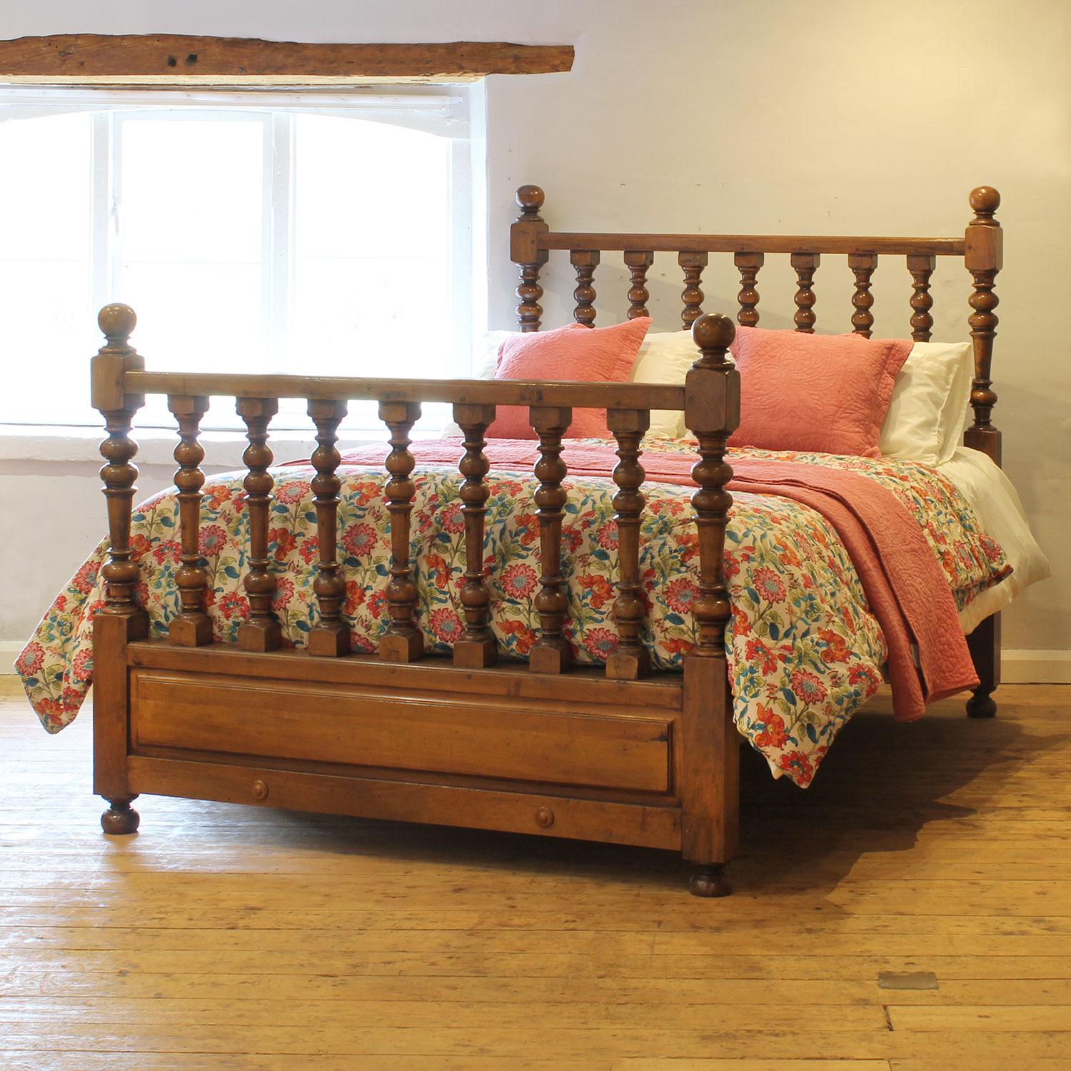 A simple spindle wooden bed in walnut from the mid-Twentieth Century.

This bed accepts a US Queen Size (or UK King Size), 5ft wide (60 in), base and mattress set.

The price includes a firm bed base for the bed frame.

The mattress, bedding and