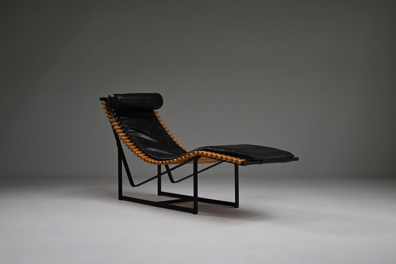 Spine back chaise longue by Peter Strassl, 1970s Germany. Designed for the Kunsthaus Munich exhibition in 1978. Black steel frame with solid wooden “spine” seat and black perforated leather cushions. Very comfortable due to the hanging “spines” and