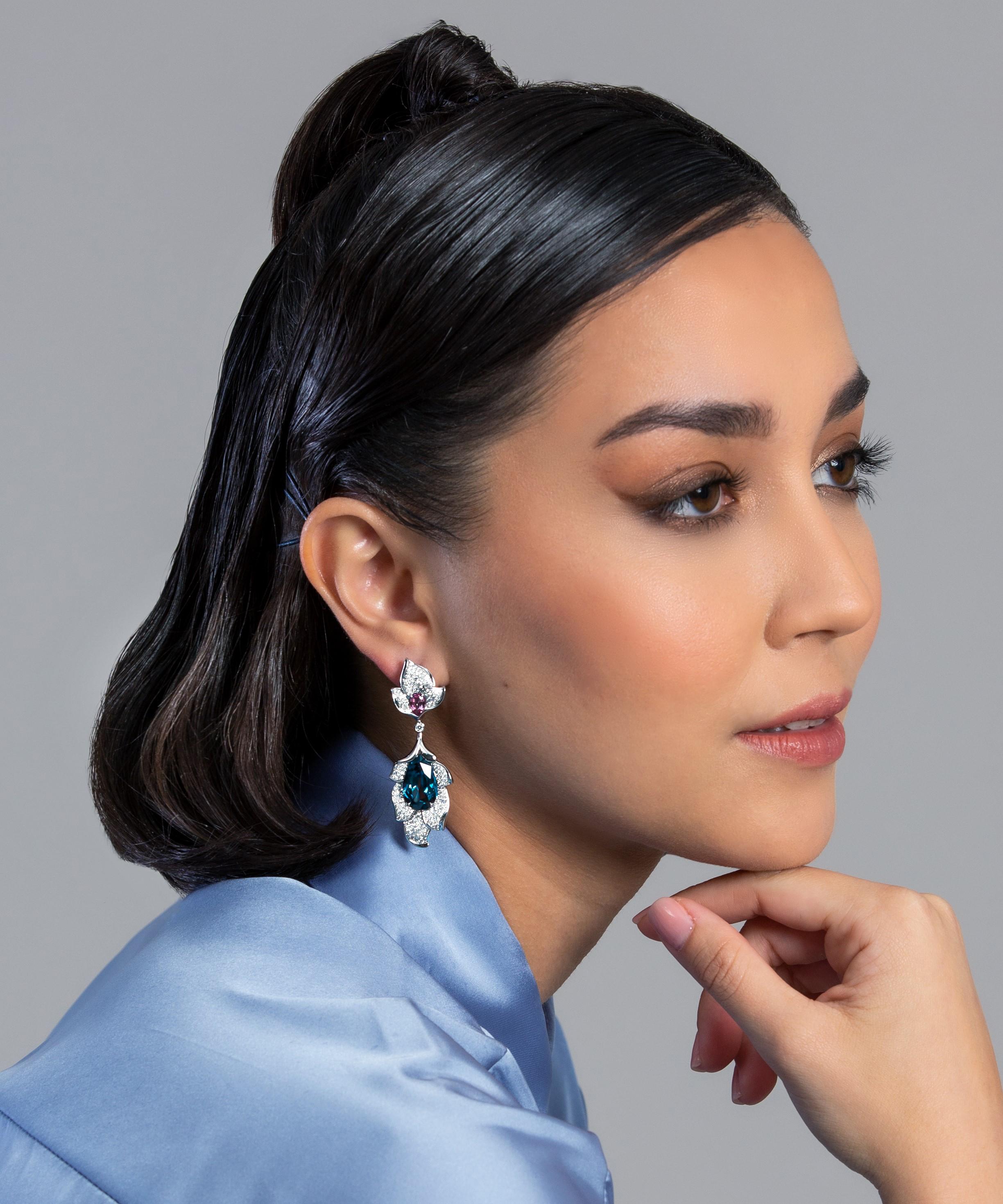 -	Pendientes de oro blanco de 18 quilates con 4 espinelas azules y rosas en forma de gota Peso total en quilates 18,16.
-	Oro blanco de 18 quilates con espinelas azules y rosas
-	2,36' de largo cada una
-	Espinelas Azul y Rosa en forma de gota