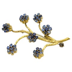 Broche Rama Flor de Zafiro Azul Giratorio en Oro Amarillo de 18 Kilates Texturado