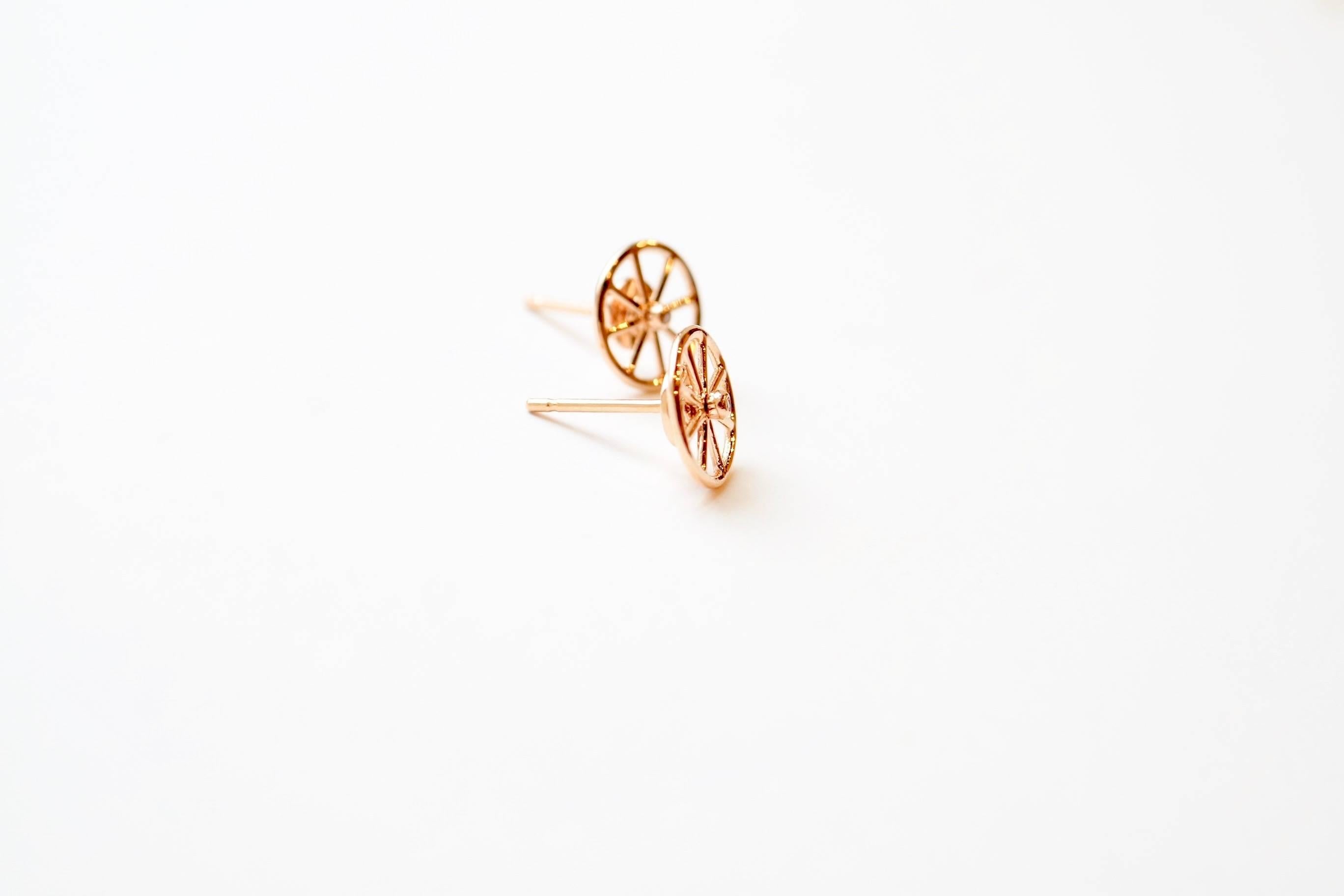 Billy Collection - Axle Stud Earrings
A pair of eighteen-karat rose gold stud earrings, each featuring a unique design of a delicately wrought wheel that may be rotated while on the ear. Each wheel is set with a single white diamond in the center of