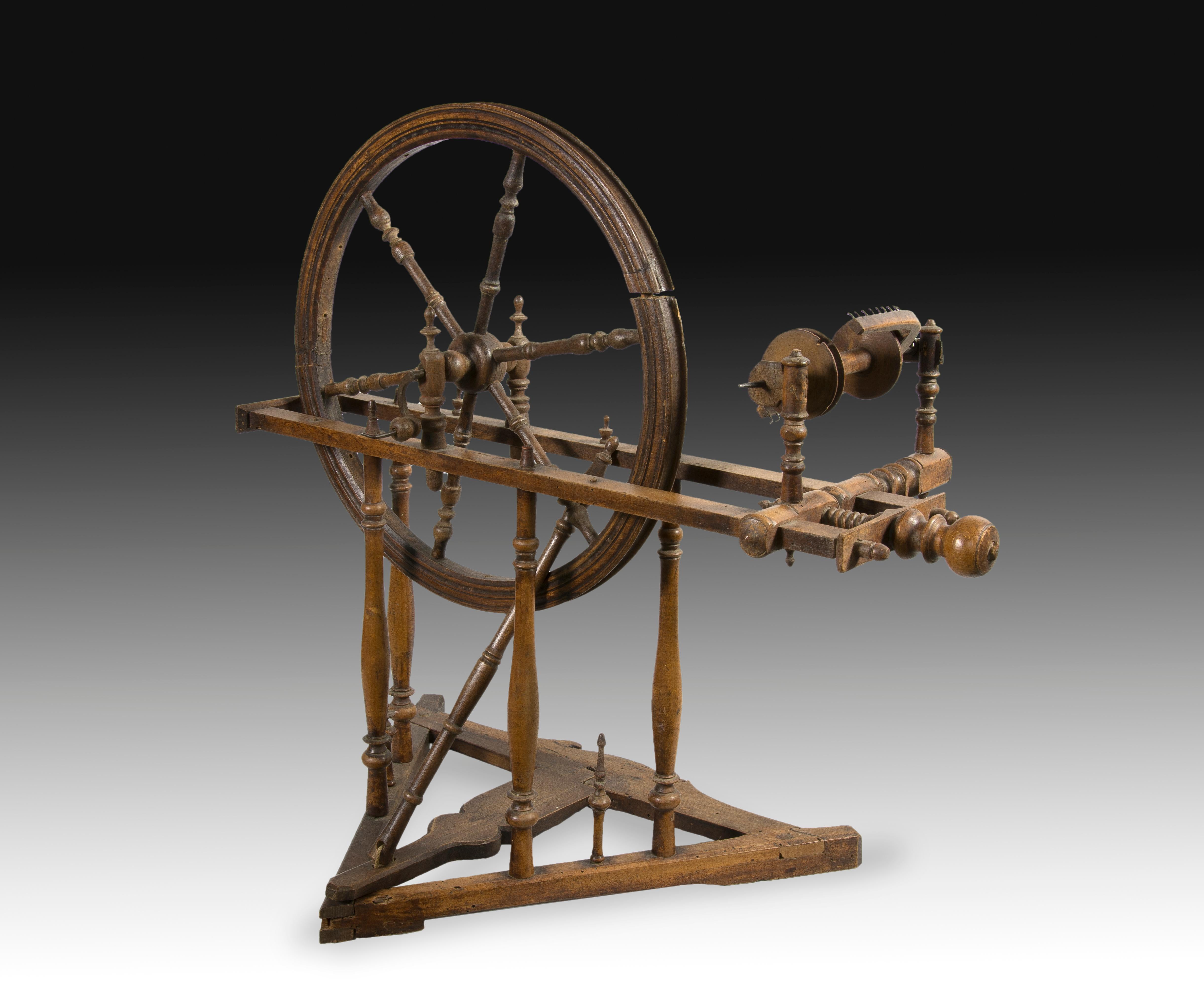 Spinning wheel. Walnut wood carved and turned. XIX century. 
 Vertical carved walnut wood spinning wheel, which has been decorated with fine lines in certain areas, and the use of balustrade pieces one and the other decorated with discs and