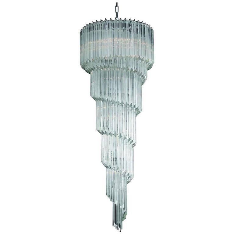 Lampadario a spirale italiano in vetro di Murano trasparente tagliato in quattro punti con la tecnica Quadriedri, montato su una cornice cromata da Fabio Ltd / Made in Italy
13 luci / tipo E12 o E14 / max 40W ciascuna
Altezza: 59 pollici più catena