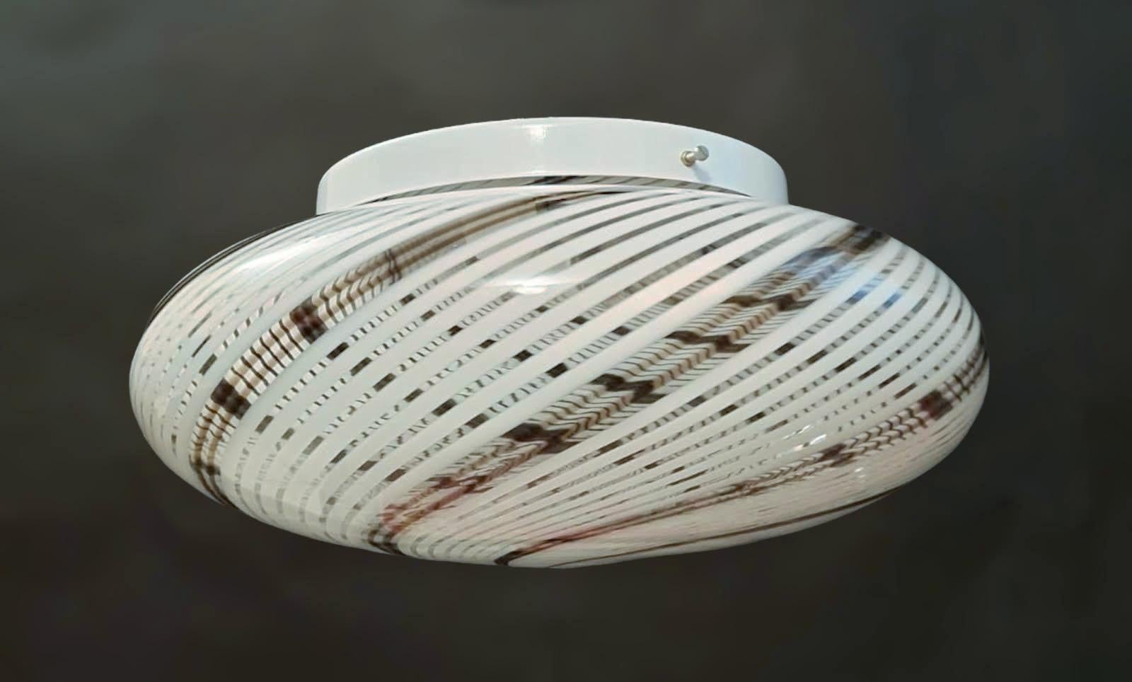 Elégante applique italienne vintage avec un seul abat-jour en verre de Murano transparent soufflé à la main avec des nervures en spirale blanches et brunes / Fabriquée en Italie par Venini, vers les années 1960.
Dimensions : diamètre 16 pouces,