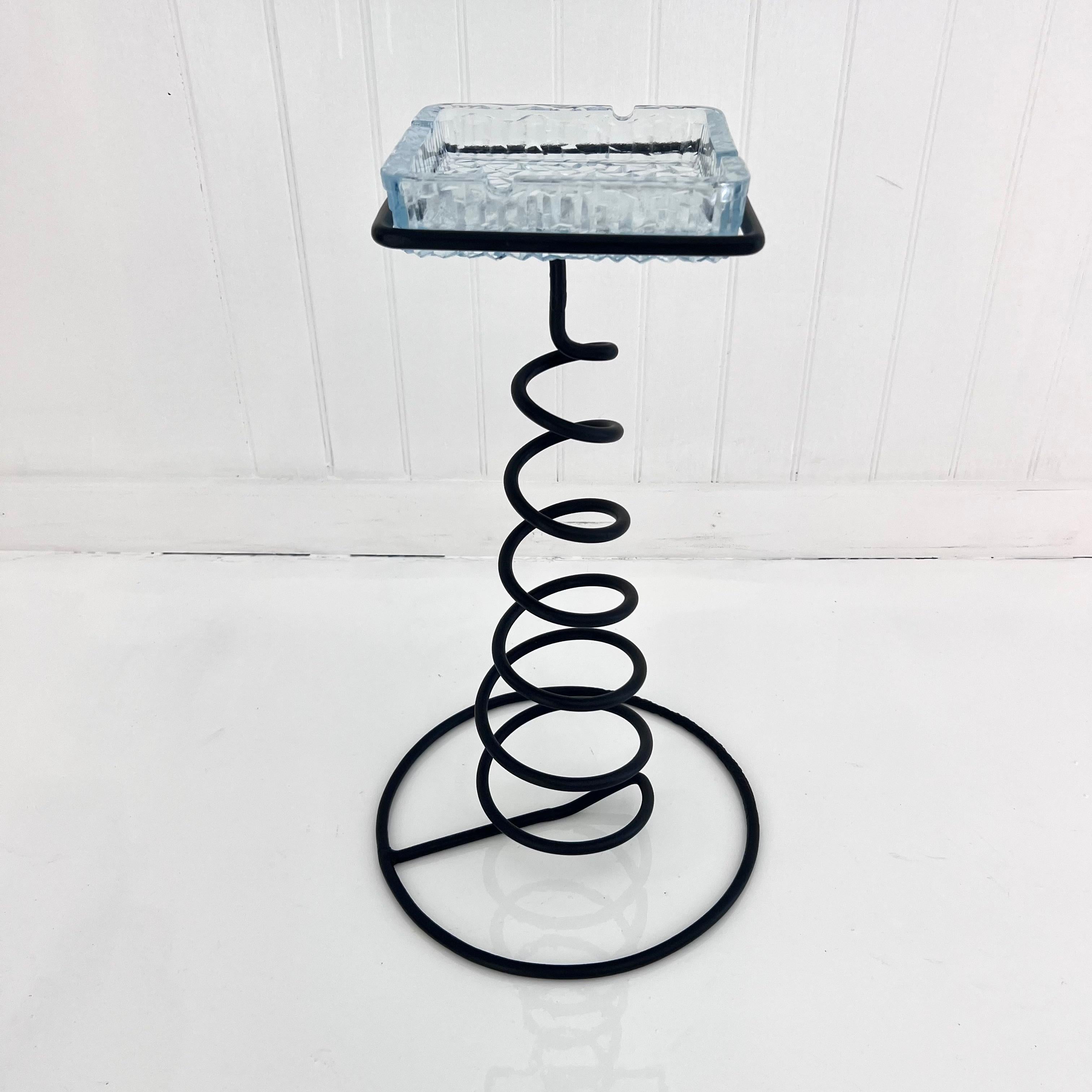 Sculptural standing catchall made of iron, twisted in an elegant spiral design. Starting small at the top and then widening out towards the bottom, until reaching the large circular base. One substantial clear crystal dish with a magnificent