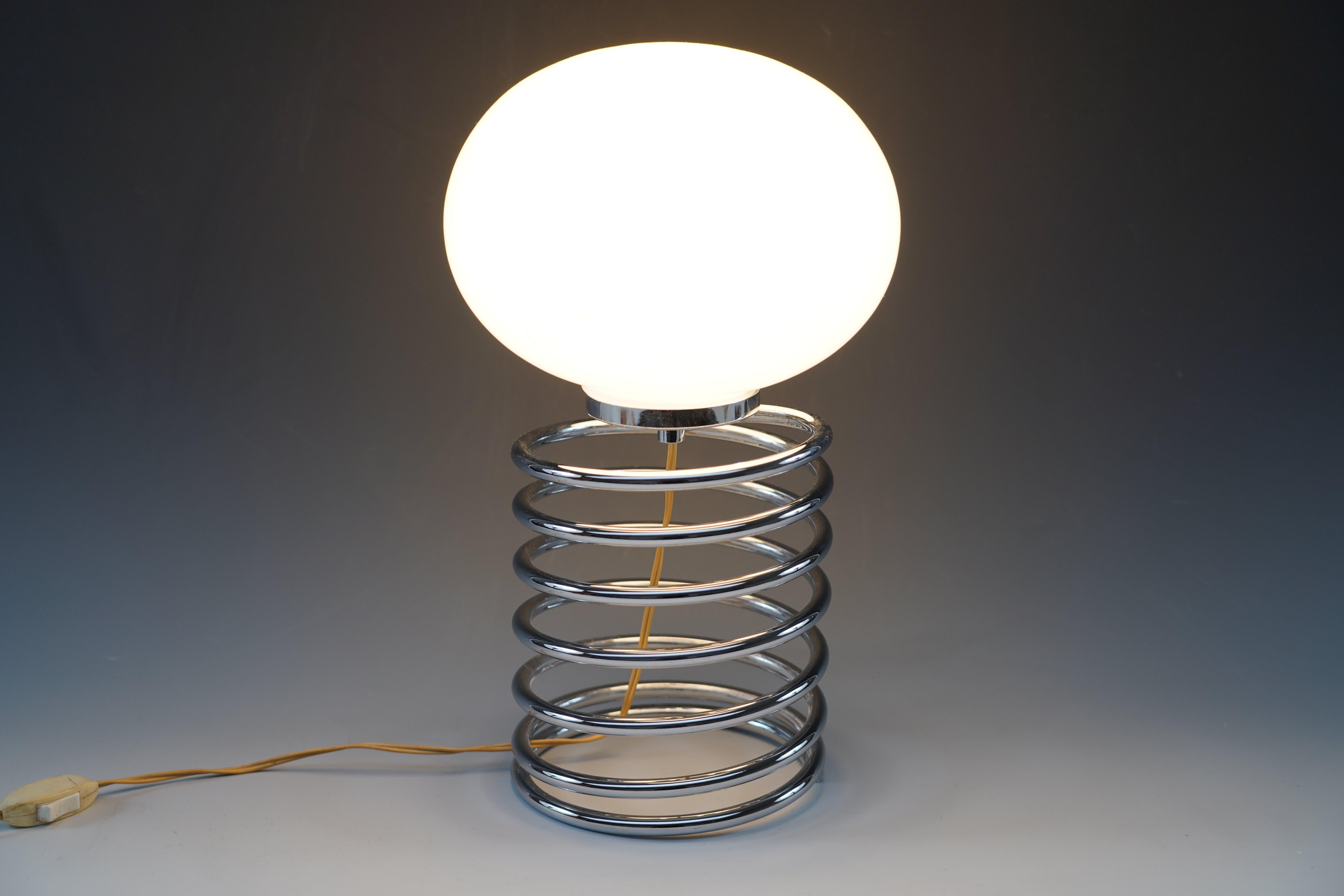 Beautiful “Spiral” model lamp typical of the 1960s attributed to the designer Ingo Maurer for Design M, chrome metal base and white opaline glass globe.

Biography :
Born in 1932 in Germany, on the island of Reichenau on Lake Constance, Ingo Maurer
