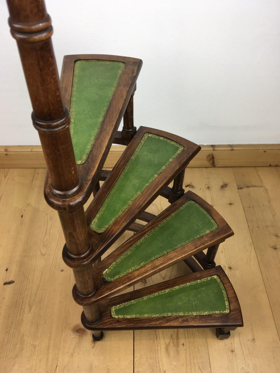 1950s spiral library step ladder. This vintage hand-carved wooden library step is spiral and has 4 steps upholstered with green leather and golden motif. This 4-step rounded library ladder on turned legs has a central post or handrail with