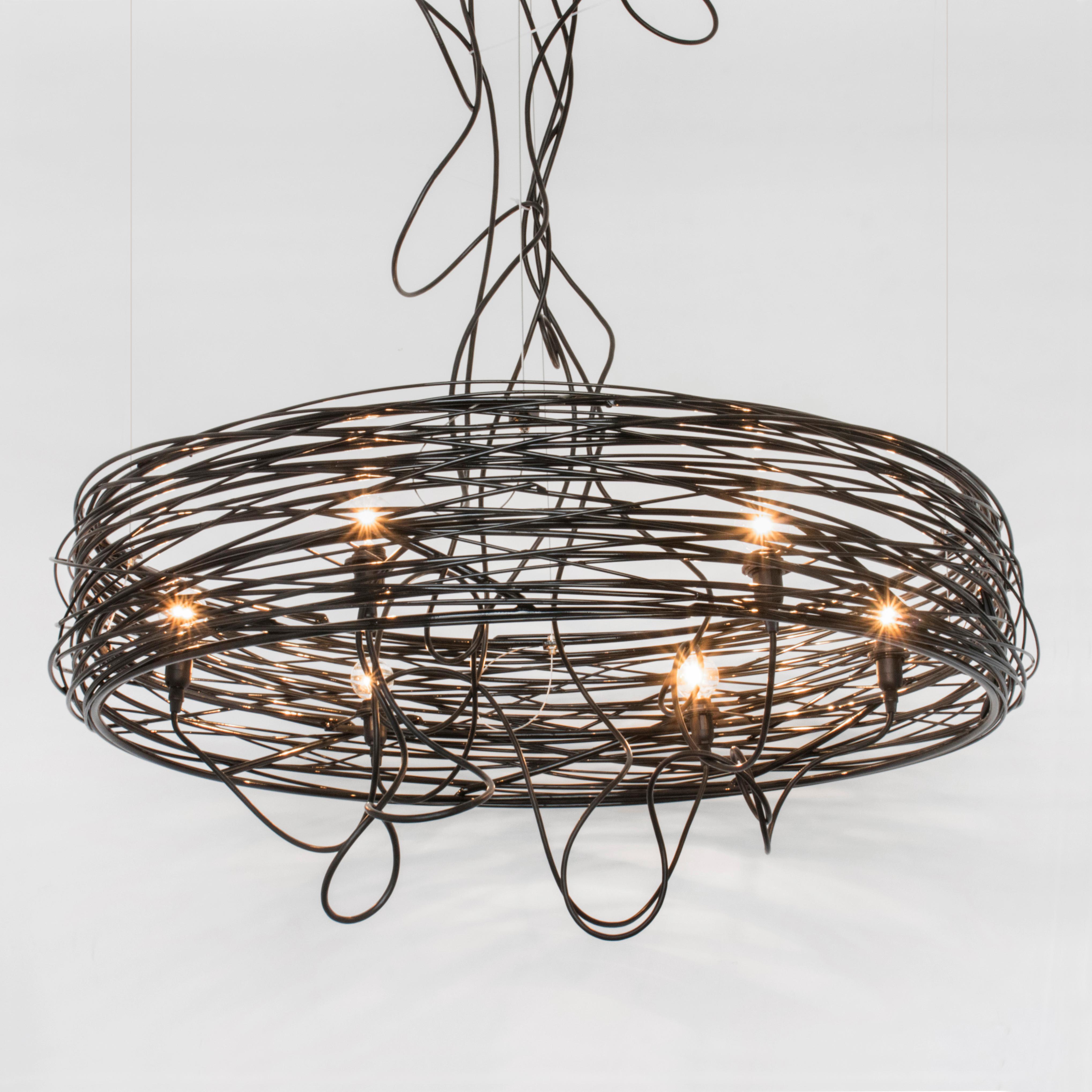 The SPIRAL NEST chandelier is composed of hand-rolled steel rods in various thicknesses, skillfully welded together. Inspired by a sketch in the artist's notebook, each Nest is slightly different, and although similar no two are identical. This