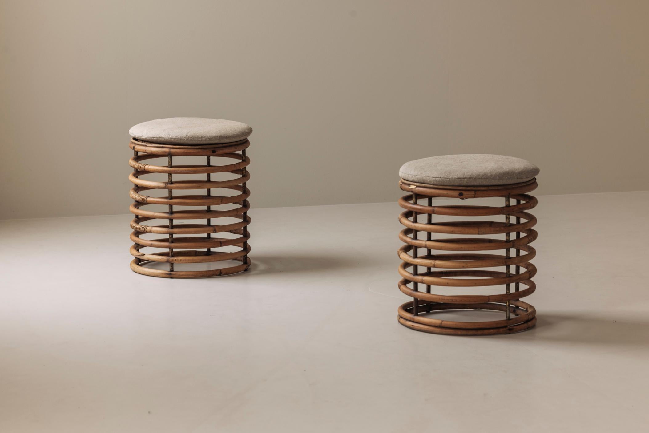 Dieses Paar Rattanstühle aus den 1960er Jahren erinnert an die entspannte Raffinesse des italienischen Designs der Jahrhundertmitte und an Tito Agnolis ikonische Arbeiten. Jeder Hocker hat einen skulpturalen, spiralförmigen Rattanrahmen, der