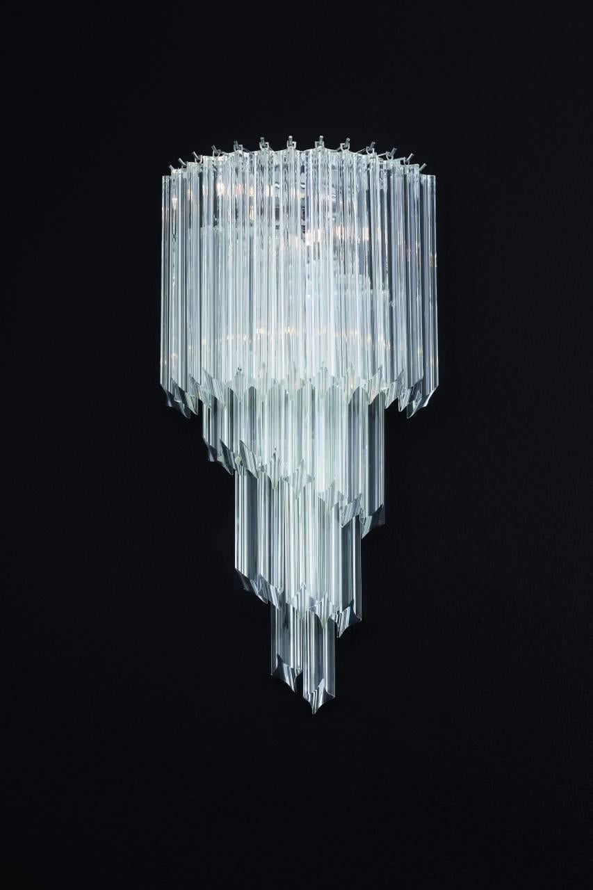 Aplique italiano con vidrios de Murano transparentes tallados a mano en cuatro puntos mediante la técnica Quadriedri, montado en un marco con acabado cromado / Diseñado por Fabio Bergomi / Fabricado en Italia
3 luces / tipo E12 o E14 / máx. 40W cada