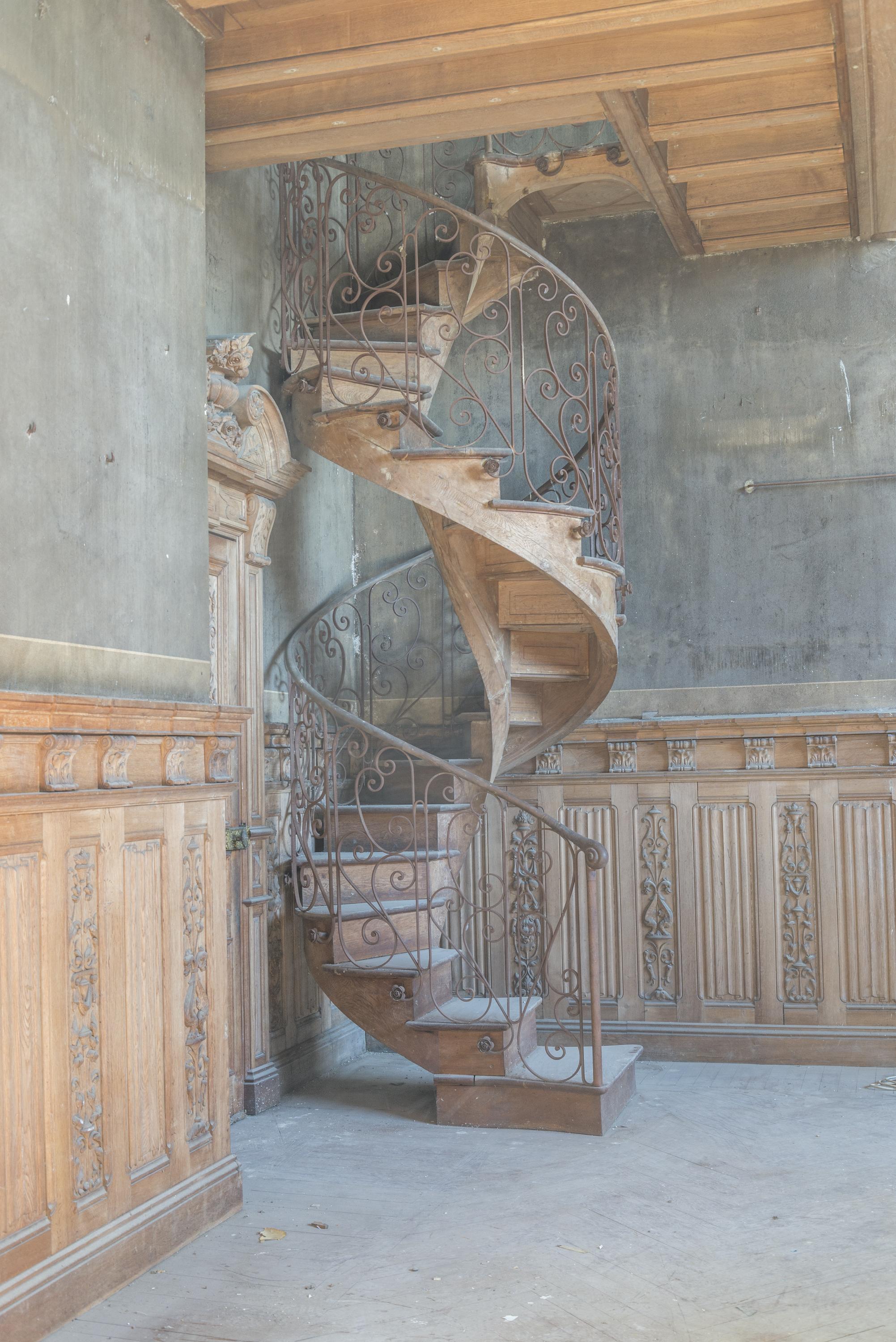 Wood Spiral staircase with a wrought iron railing For Sale