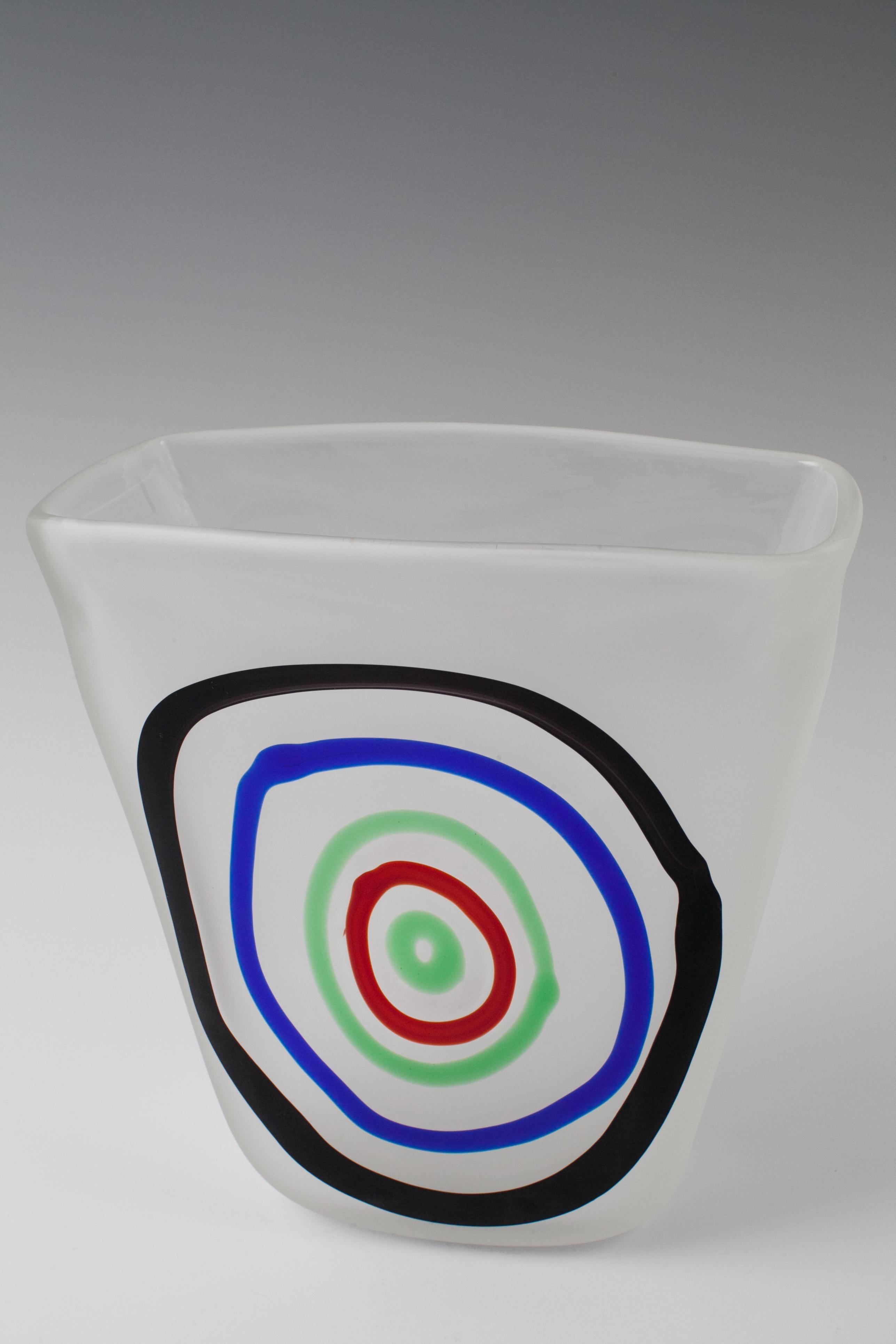 Four sides to scale expanding corpus .
Measure: H 19.5 cm.
Fulvio Bianconi for: I.V.R. Mazzega. Colorless glass, blow molded with concentric Ringaufschmelzungen in green, red , violet and blue .
Unique work in commission for Bruno Daneses