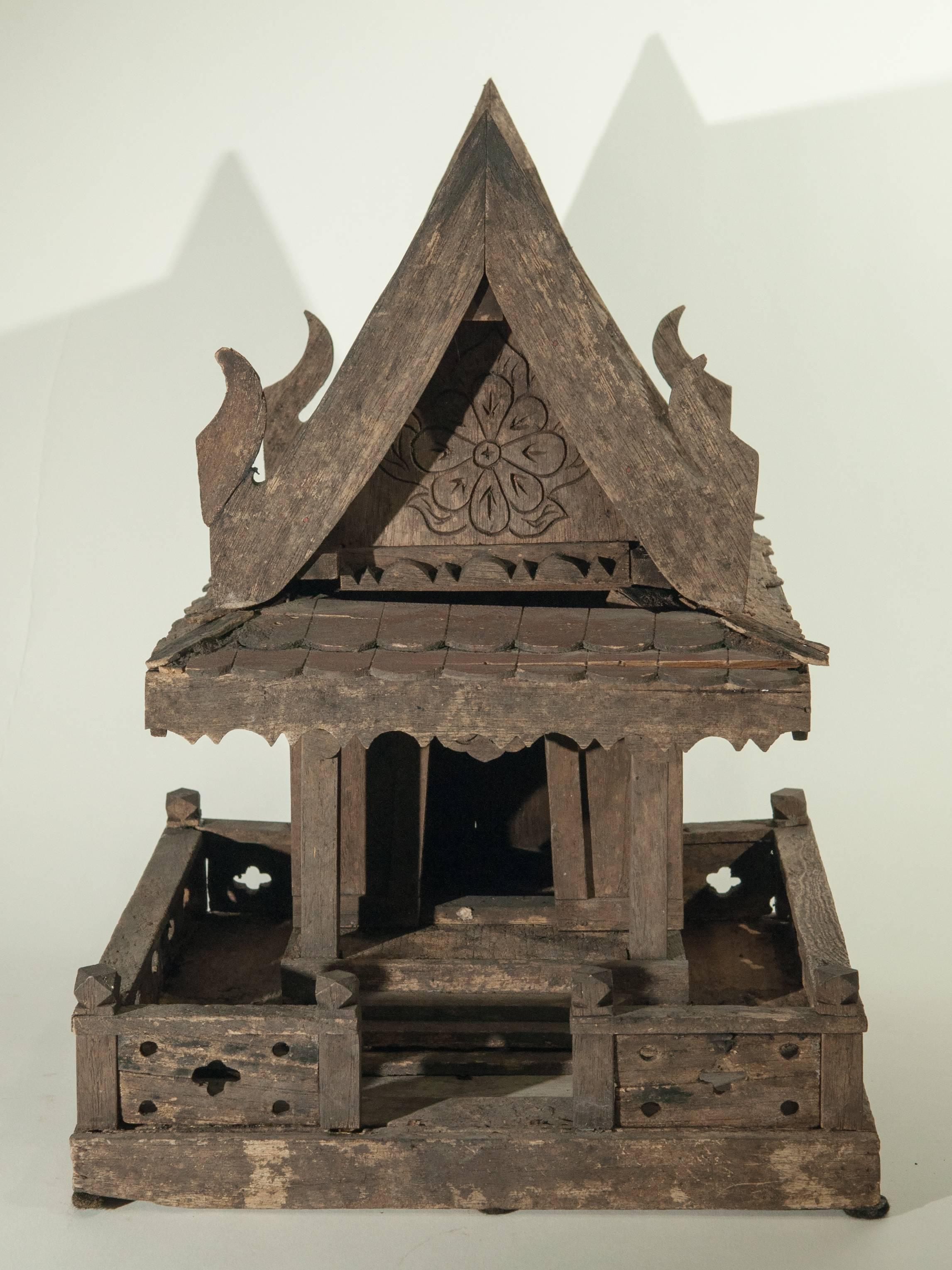Spirit House from Northern Thailand. Teak, mid-late 20th century.
Offered by Bruce Hughes.
This rustic spirit house models a traditional Thai rural home, with a fence and porch, and incorporates the Naga motif bargeboards running along the edge of