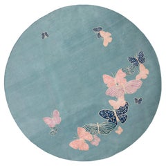 „Spirit in the Sky“ – runder, handgeknüpfter nepalesischer Teppich in Pfirsichfarbe mit Schmetterlingsmotiv. Wolle & Seide