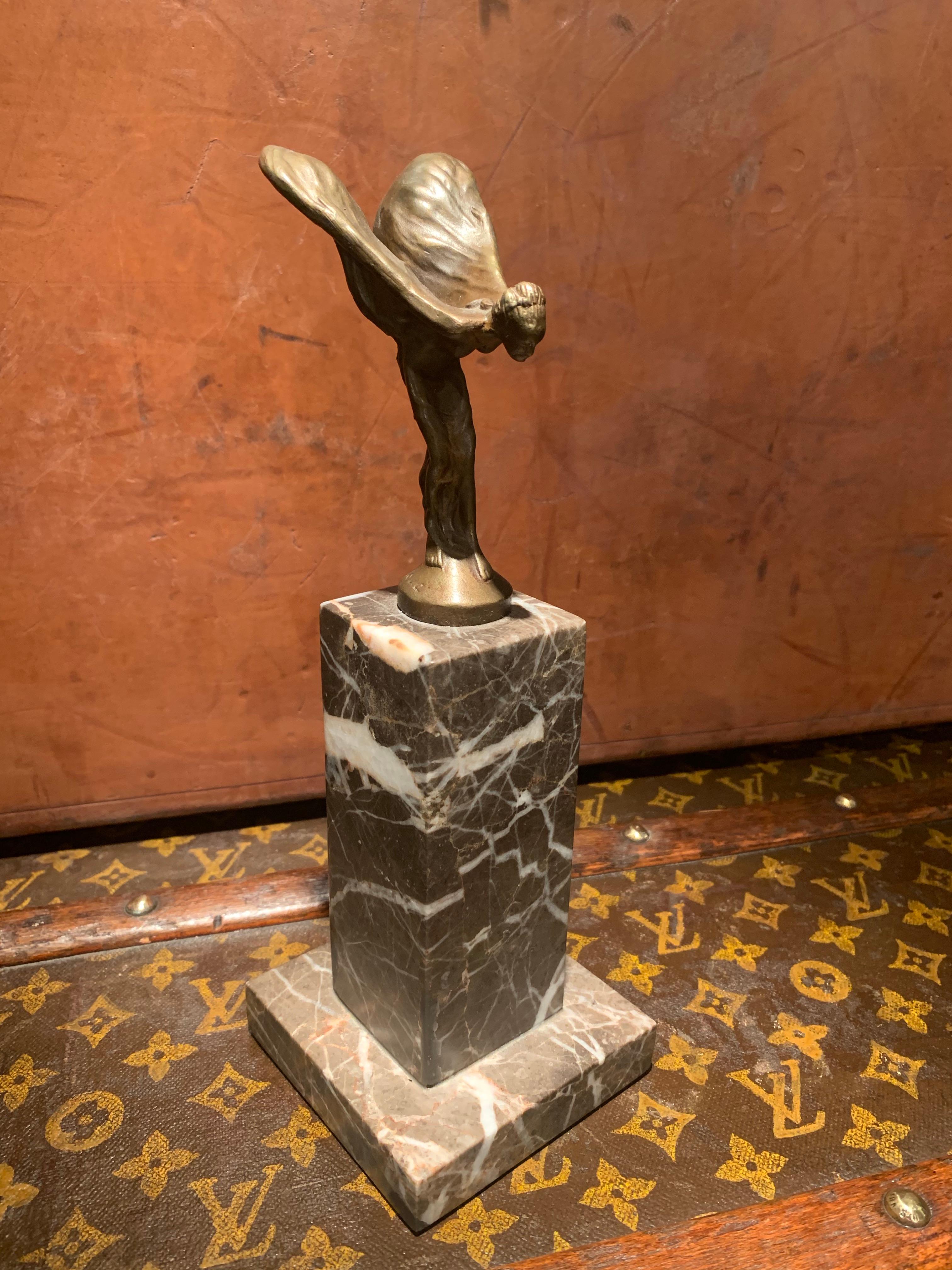 Small statue in Bronze which represent the Spirit of Ecstasy made by Jean Patoue (1887-1936), which stand on a grey Marble base.
This object could be display as a decoration piece on a desk or shelves.

Condition:
The Bronze has a beautiful