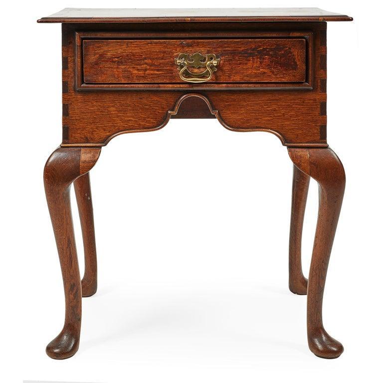 A fine example of a early English side table with single beaded drawer under thin molded top and having shaped front and side aprons with beading, over coiled cabriole legs and pad feet. Unusual dovetail quoins to corners. Whimsical vernacular form