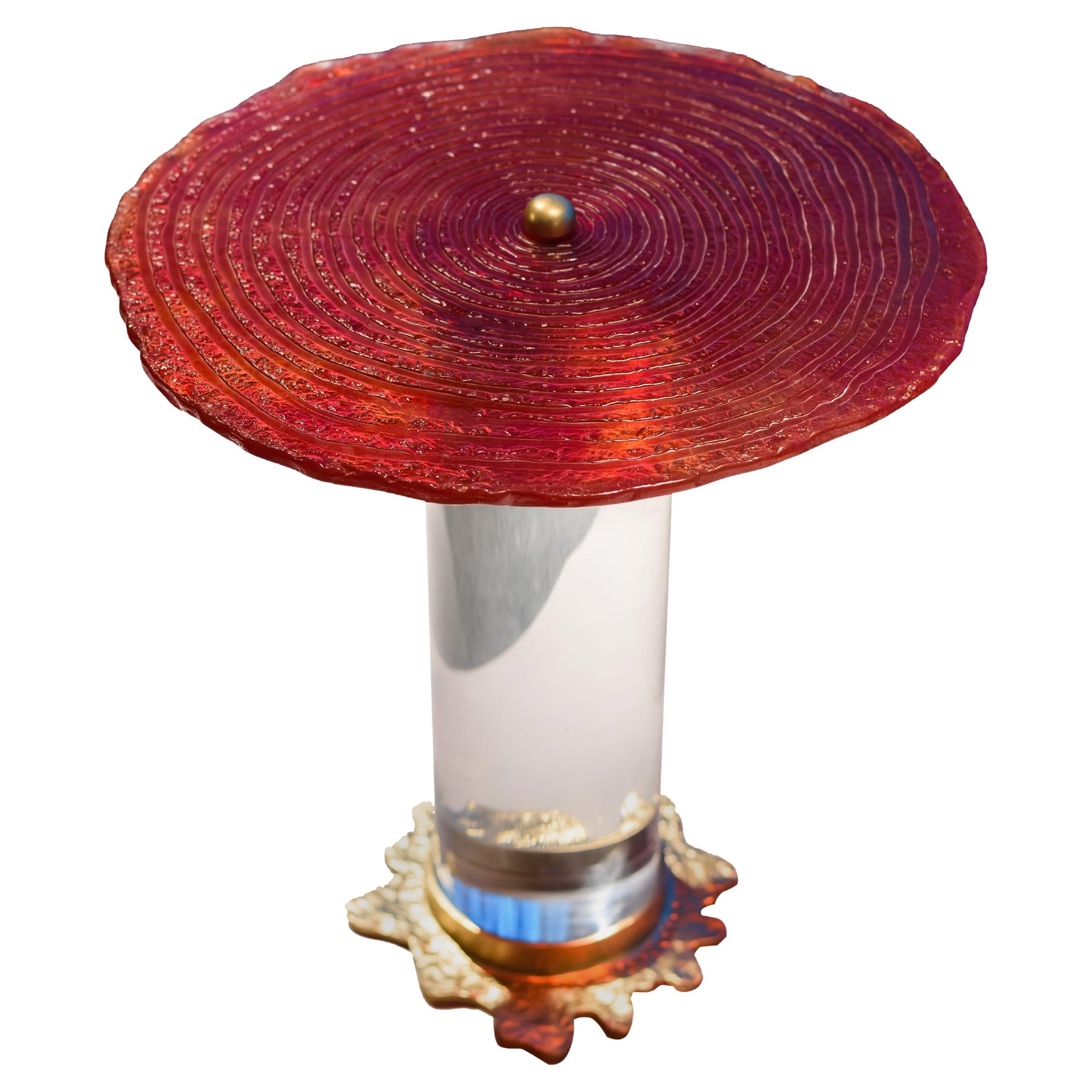 Der Splash II Tisch ist ein atemberaubendes Zeugnis handwerklicher Kunstfertigkeit, das eine einzigartige Mischung aus Materialien und Techniken präsentiert. Sein Hauptmerkmal ist die faszinierende, handgefertigte Glasplatte, die das Licht auf eine