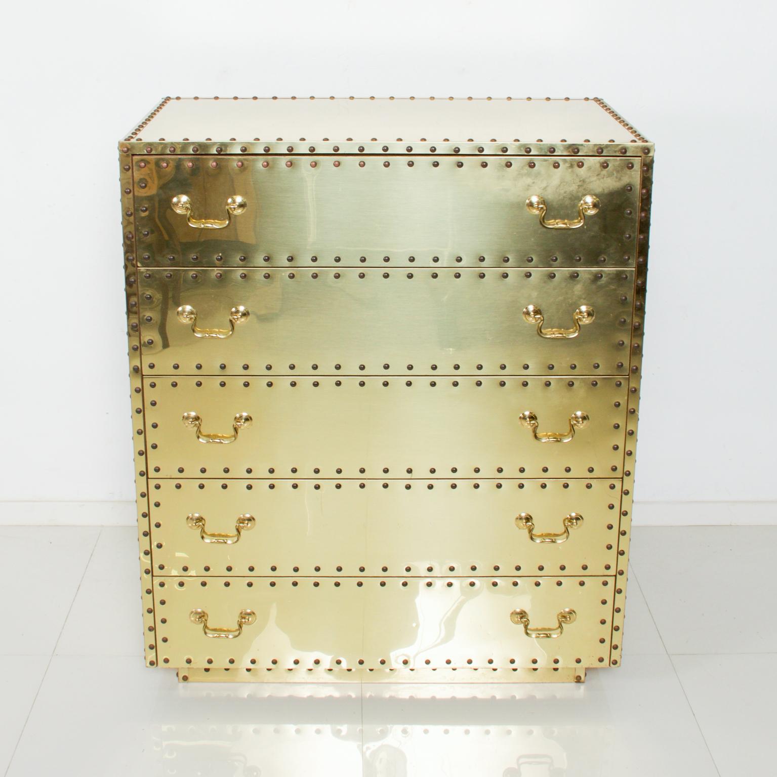 Dresser Chest
1970s Hollywood Regency Disco Highboy Chest by Spanish Design House SARRREID Ltd of Spain 
5 Drawer Mirrored Campaign Brass with Nail Head Trim
Dimensions: 40.5 H x 20.25 D x 34.25 W
Original Unrestored Condition: stains, scratches,