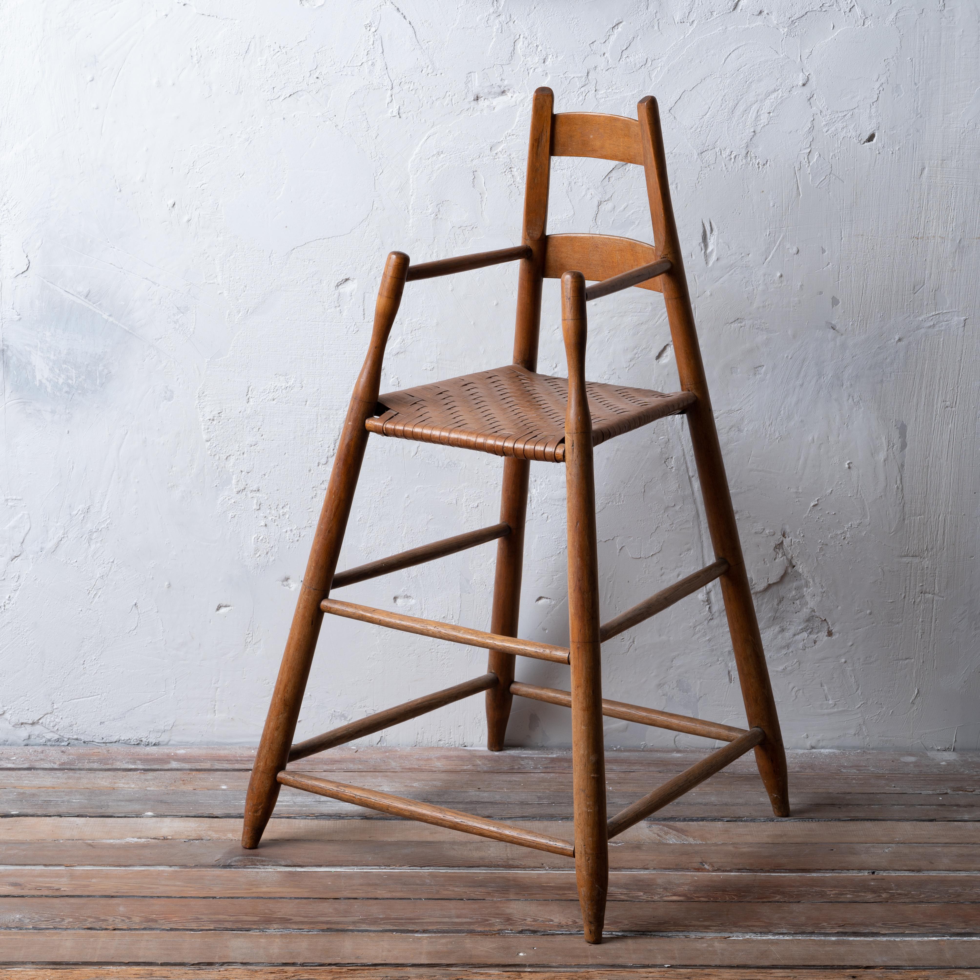 A highly splayed leg American ladder-back high chair in maple and oak with split hickory seat, first half 19th century.  

20 ½ inches wide by 20 inches deep by 36 inches tall; seat height 22 inches

