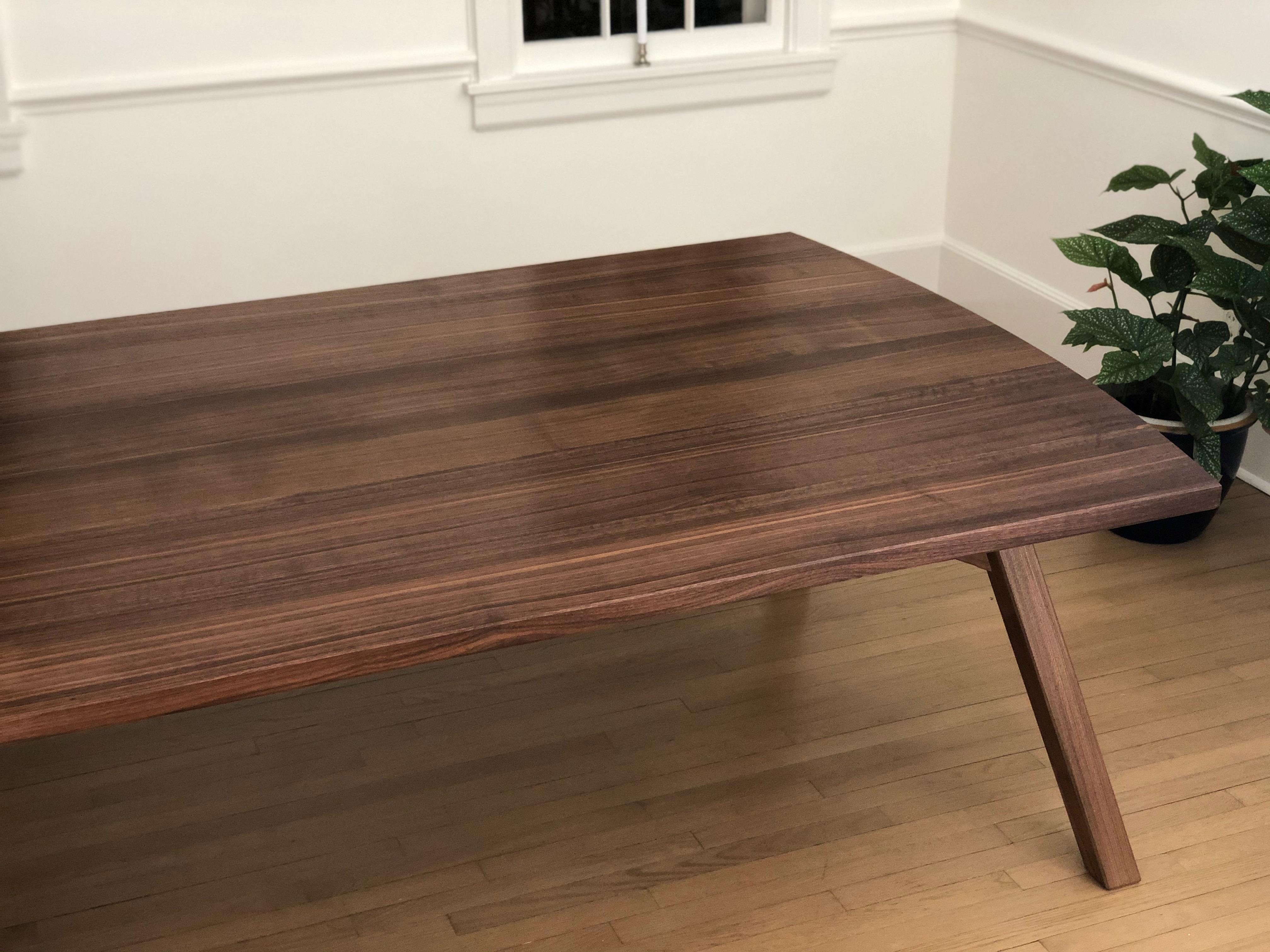 This dining table takes inspiration from the traditional Japanese bell tower in its use of a splayed leg structure that appears to feature square section legs. Upon closer inspection one realizes that the legs are a parallelogram shape, unique to