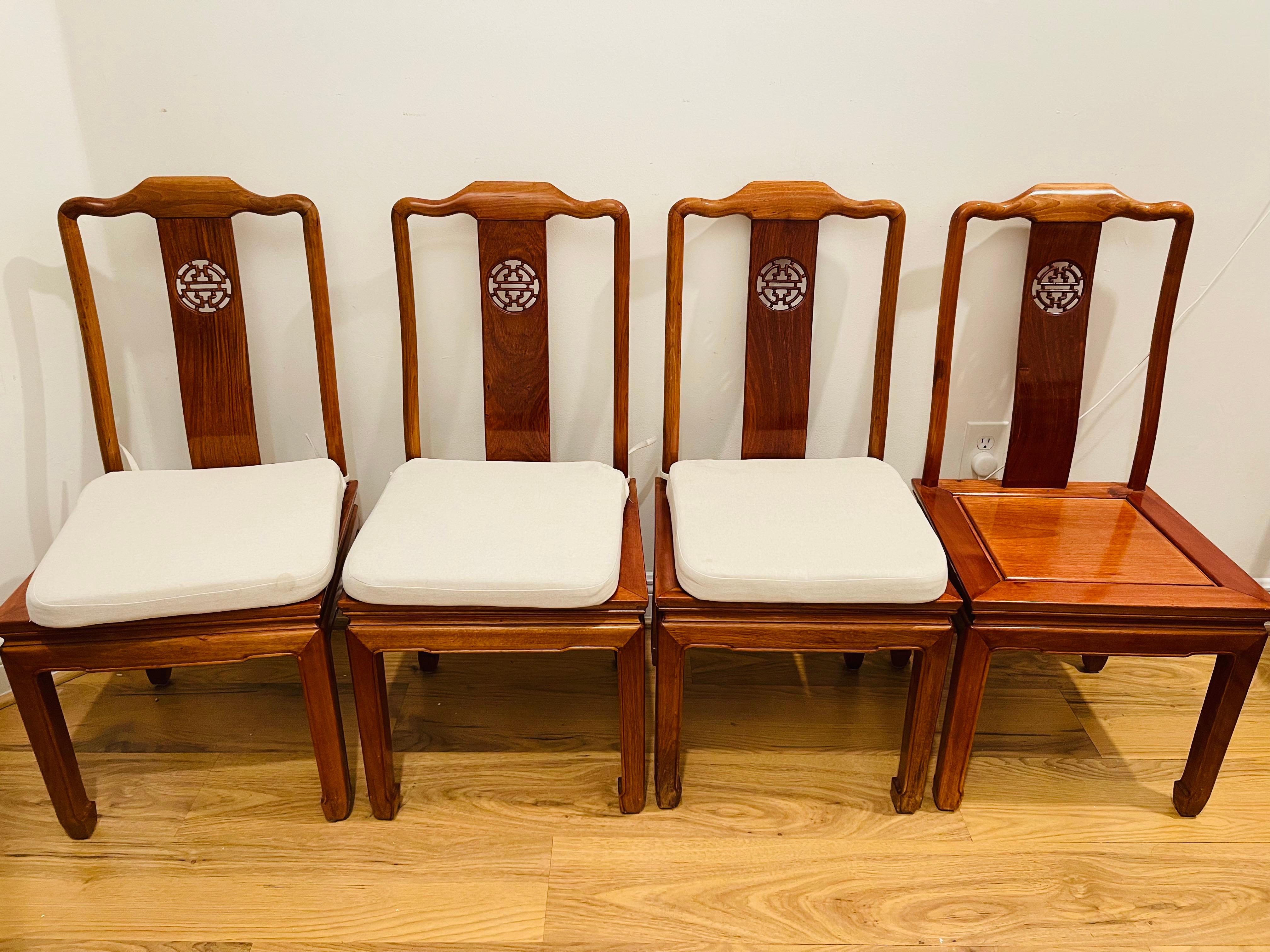 4S Set di sedie da pranzo cinesi vintage in legno di teak con il simbolo della longevità intagliato sullo schienale. Legno di teak di colore ambrato splendidamente lucidato. 4 cuscini di lino inclusi.