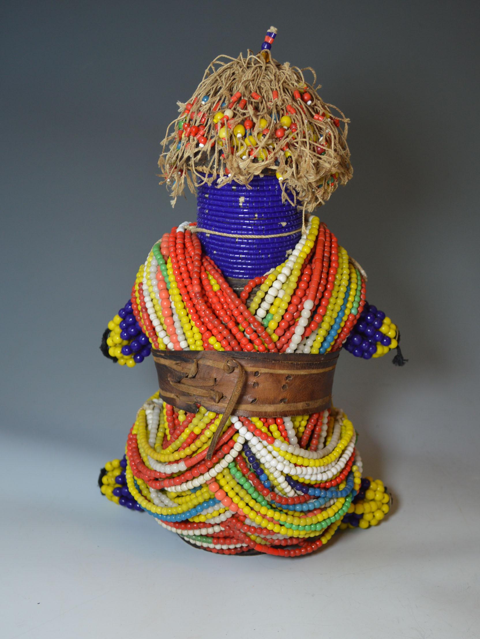A splendid large multi colored beaded fertility doll from the Fali of Cameroon
The doll incorporating the combined features of a phallus and a child made from a wood central section covered in strands of multi colored beads with string beaded hair