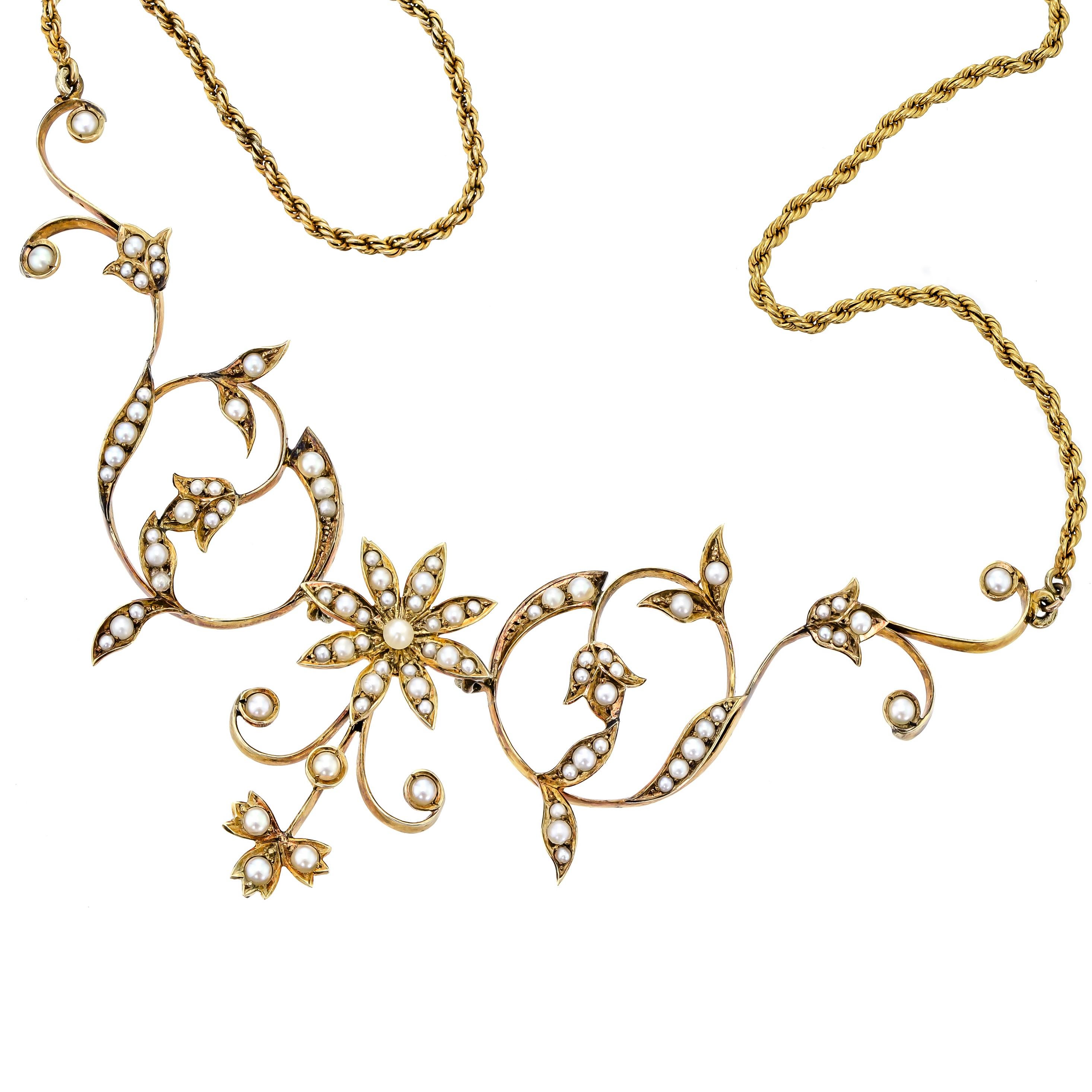 This beautiful and feminine antique Edwardian 14kt yellow gold pearl floral necklace contains numerous small pearls set into a foliate and floral motif displaying elegant Edwardian design characteristics. The stunning floral motif is crafted into a