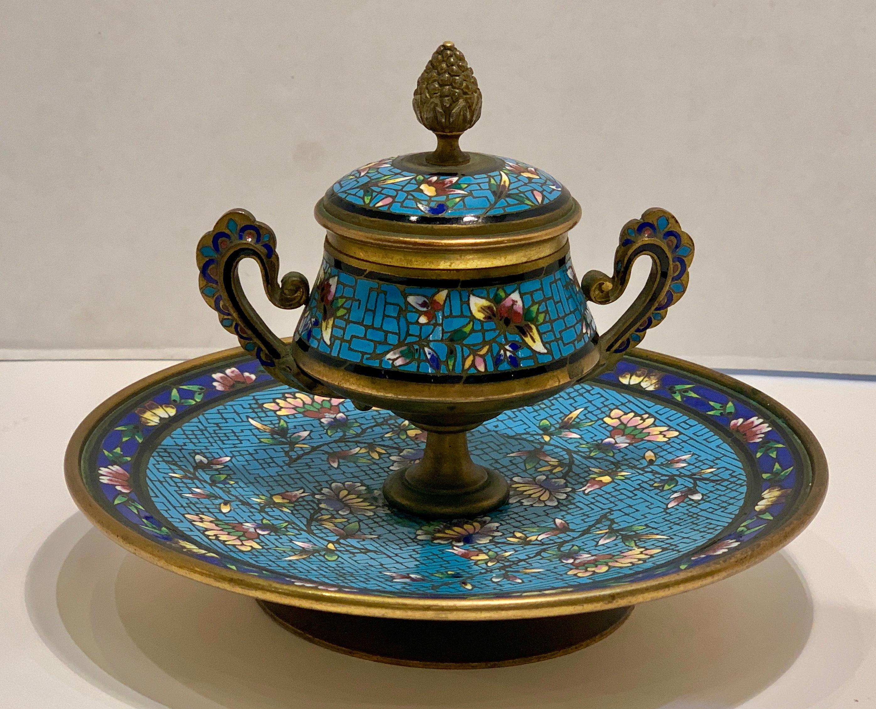 A very fine, handmade, French gilt brass and Champleve enamel antique footed encrier or inkwell features an inkpot with scalloped handles and a hinged lid with an acorn finial top. Inkwell is richly decorated in colorful, jewel toned Champleve