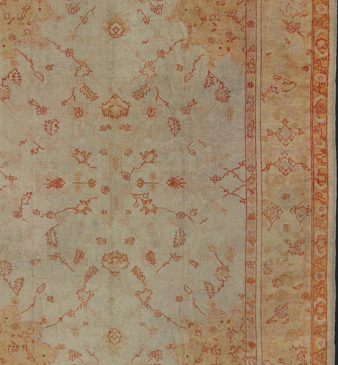 Antique Turkish Oushak Carpet In Red, Cream, and Yellow with A Muted Design  In Good Condition For Sale In Atlanta, GA