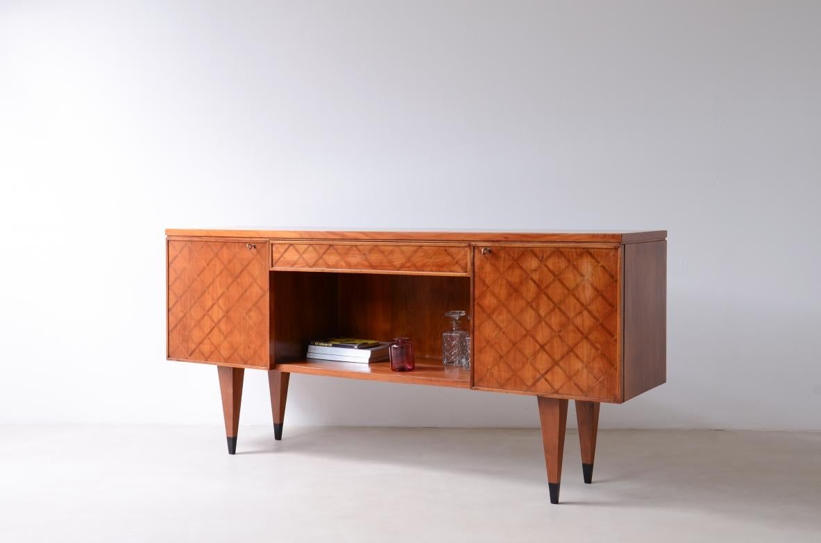 Gio Ponti (1891-1979)

Splendid highboard with a wooden front inlaid with a checkerboard pattern, two side doors with a central drawer and an open compartment, ebonized wooden tips.

Certified by the Gio Ponti Archive 1950's