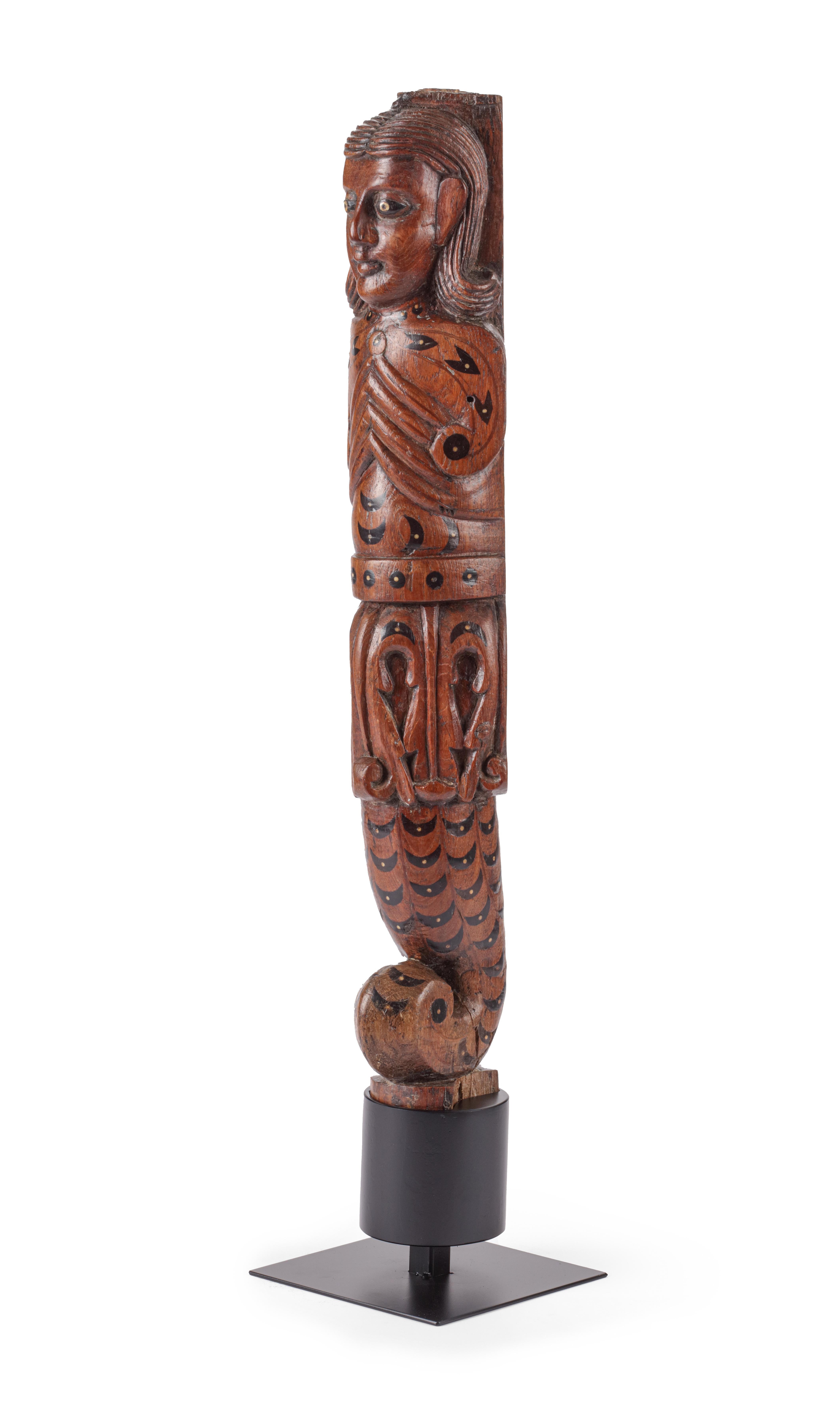 A fine Indo-Portuguese inlaid teak wood figure of Nagini
India, Goa, 17th century

Measure: H. 55 cm
(with stand, and with ring for wall hanging)

The sculpture can be perceived as such but probably is one of four legs of an Indo-Portuguese