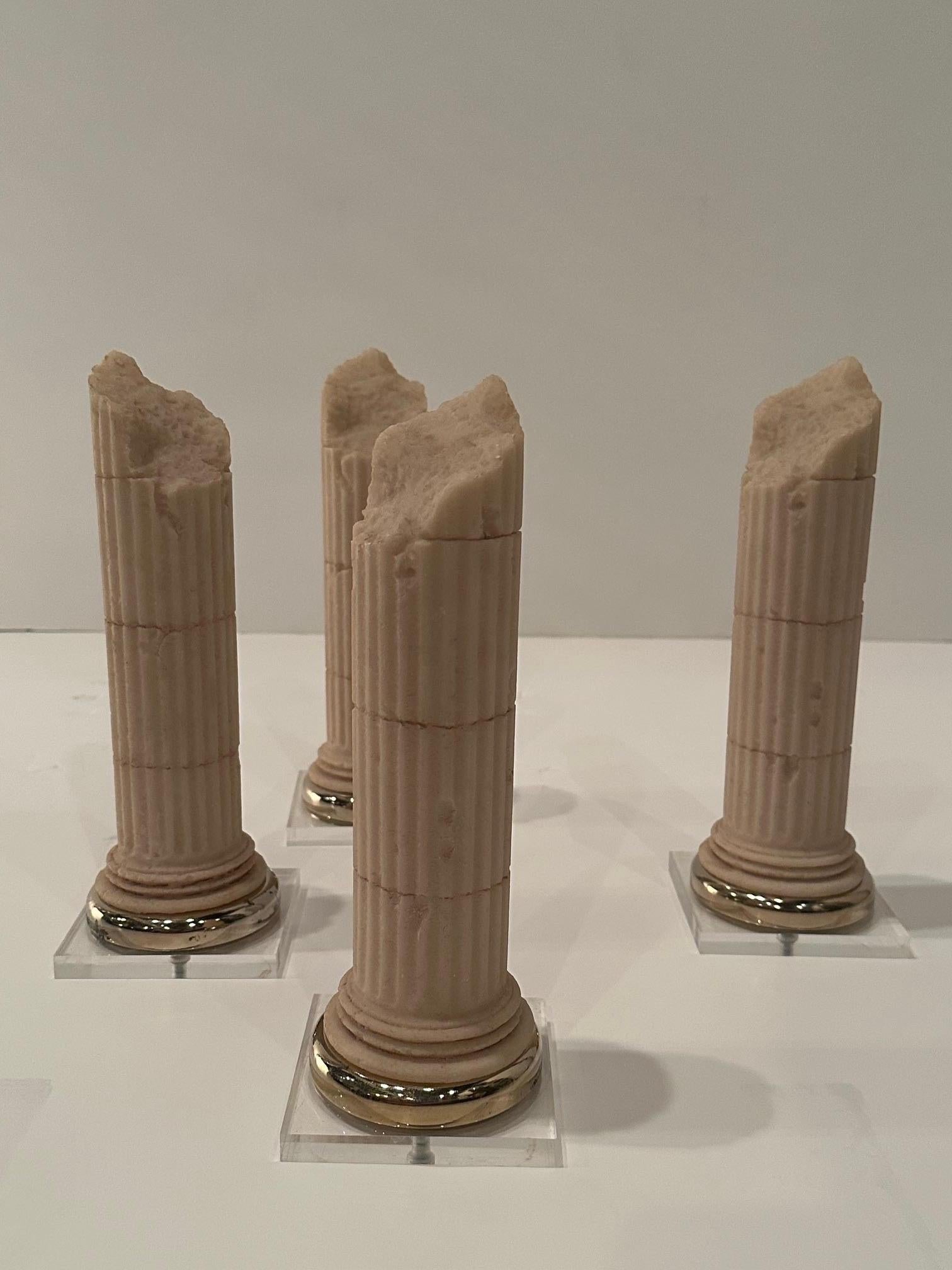 Auffälliger Satz von 4 dekorativen Säulen im neoklassizistischen Grand-Tour-Stil, Tischskulptur aus Steinguss auf quadratischen Lucite-Sockeln.  Eine Verzierung aus Messing umgibt den Boden.