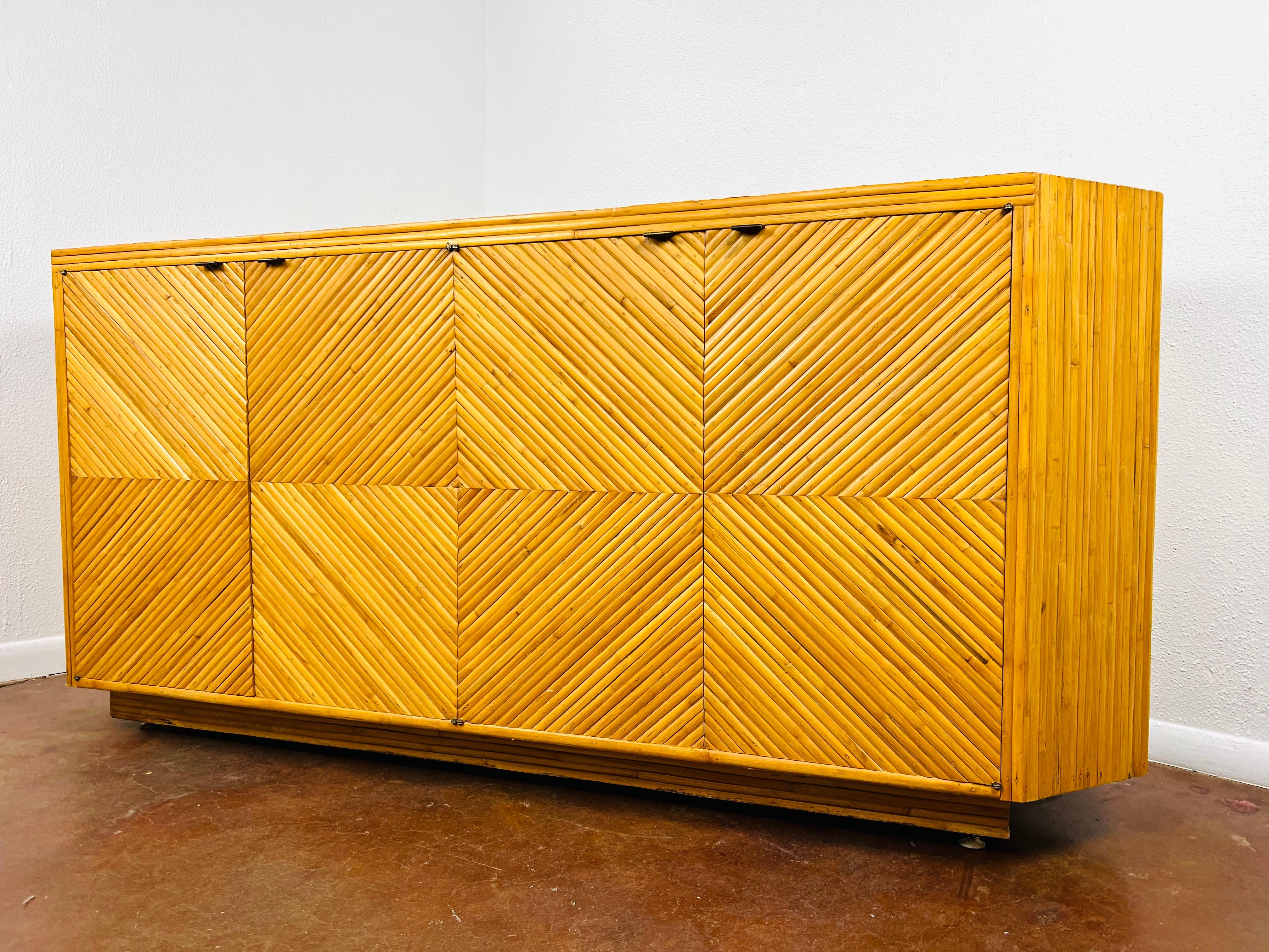 Exceptional split bamboo credenza/sideboard in excellent vintage condition with some minor age appropriate wear and tasteful patina. Diagonally applied split bamboo veneer over solid hardwood case construction. The cabinet is finished completely,