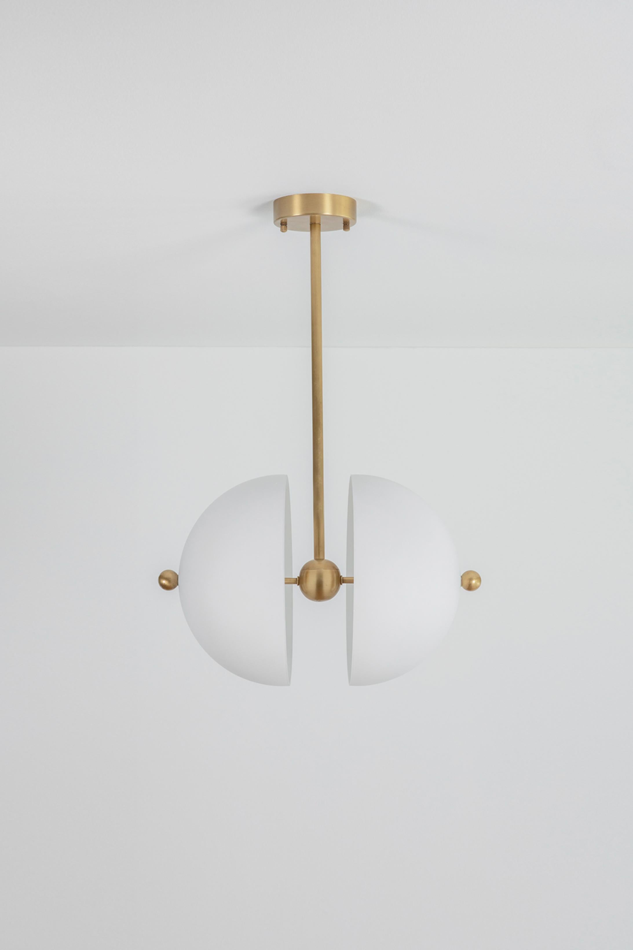 Split circle pendant lamp by Square in Circle
Dimensions: H 69 x W 45 x D 35 cm
Materials: Brushed brass finish, white lowder coated metal, white glass

Minimalistic white glass and brass pendant light. Two glass domes are attached to the brass