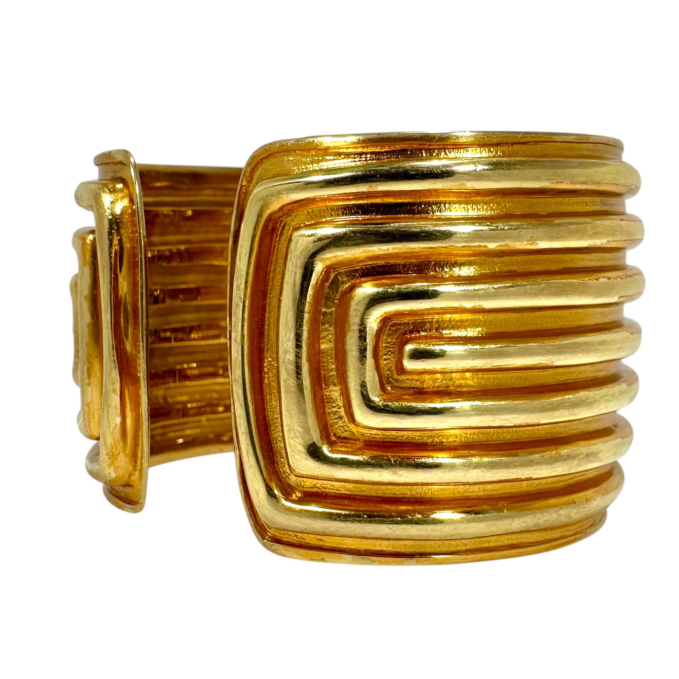 This truly unique split front 18K pink and yellow gold wide hinged cuff bracelet is certainly a one of a kind offering by the venerated house of Tiffany. Bombee high polish yellow gold raised linear motifs soar above a pink gold, lightly hammered