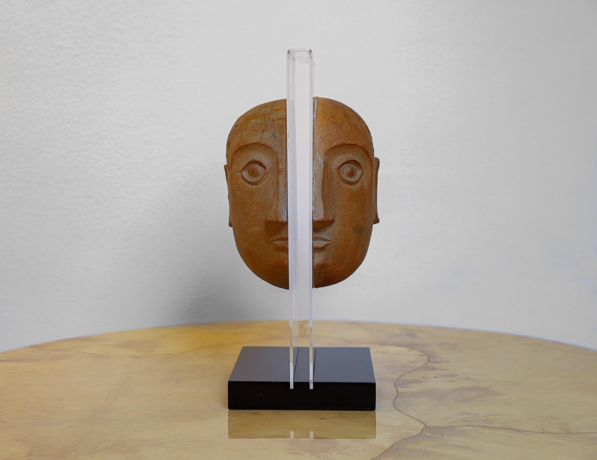 This is an interesting sculpture for Bennington Potters by artist David Gill (1922-2002) depicting a head with imprinted numbers made of two halves. The two stoneware halves are attached to a piece of lucite that is attached to a rectangular