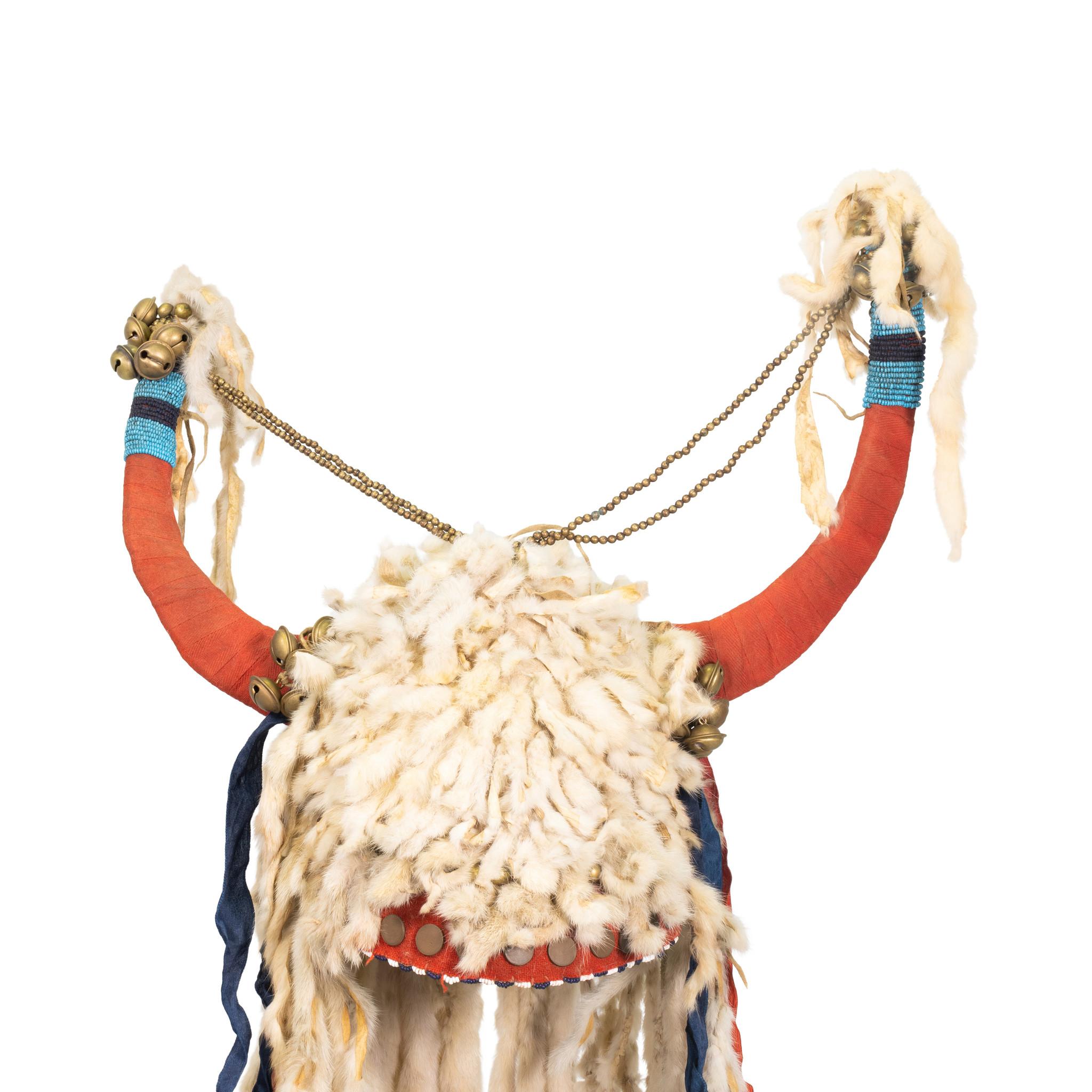 Heavily adorned split horn headdress with ermine drops, silk ribbons, hawk bells, stroud covered horns, brass trade beads and brass buttons on red stroud brain tanned buffalo cap. Stunning example from the 19th century. Would display nicely in a