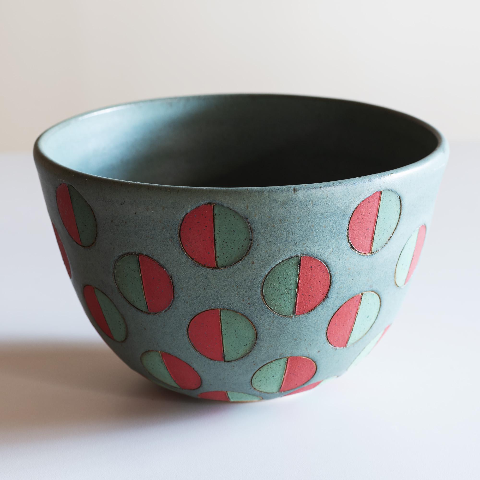 Handsome, large stoneware vessel with split polka dots in green and red.