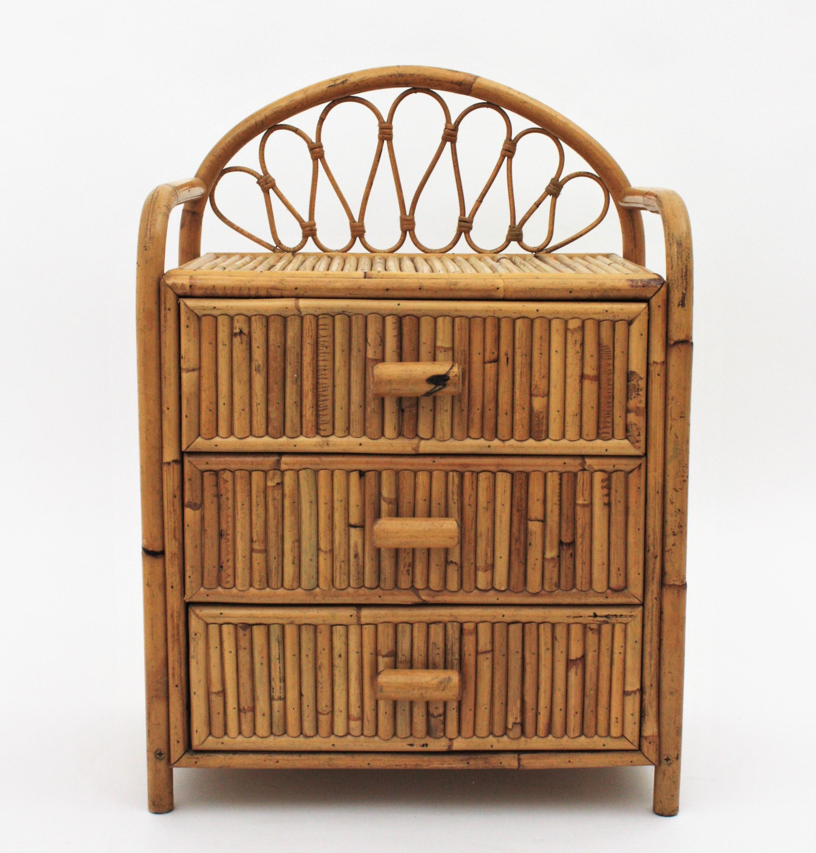 Spanish modern bamboo night stand or small chest with three drawers, Spain, 1970s 
Beautiful split reed bamboo and rattan small chest, end table or bedside table with a decorative crest.
This small chests have a wood and bamboo construction