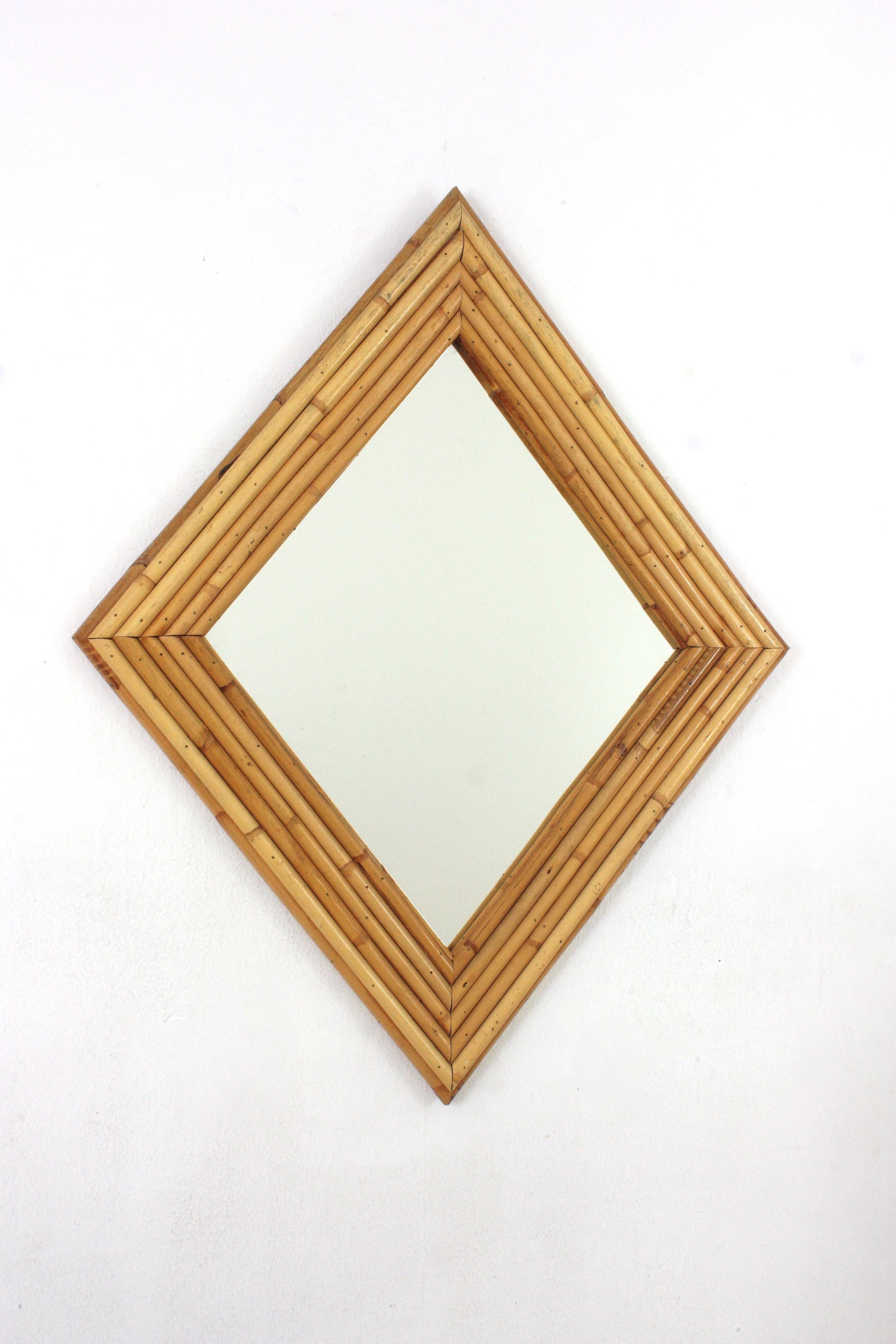 Rhombus-Wandspiegel aus der Mitte des Jahrhunderts, gespaltenes Schilf, Bambus, Rattan, Italien, 1960er Jahre.
Dieser auffällige rhombusförmige Spiegel wurde in Handarbeit aus Bambusrohr und Rattan gefertigt. Der Rahmen besteht aus sechs Schichten
