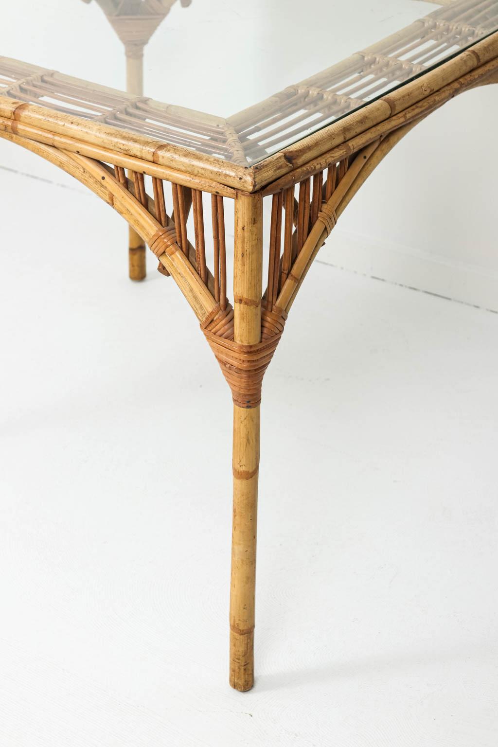 Split reed card table with glass top insert and four matching rounded back chairs. Please note of wear consistent with age including minor reed loss and loose woven strings on the joints of the chairs and table. Please also note that the