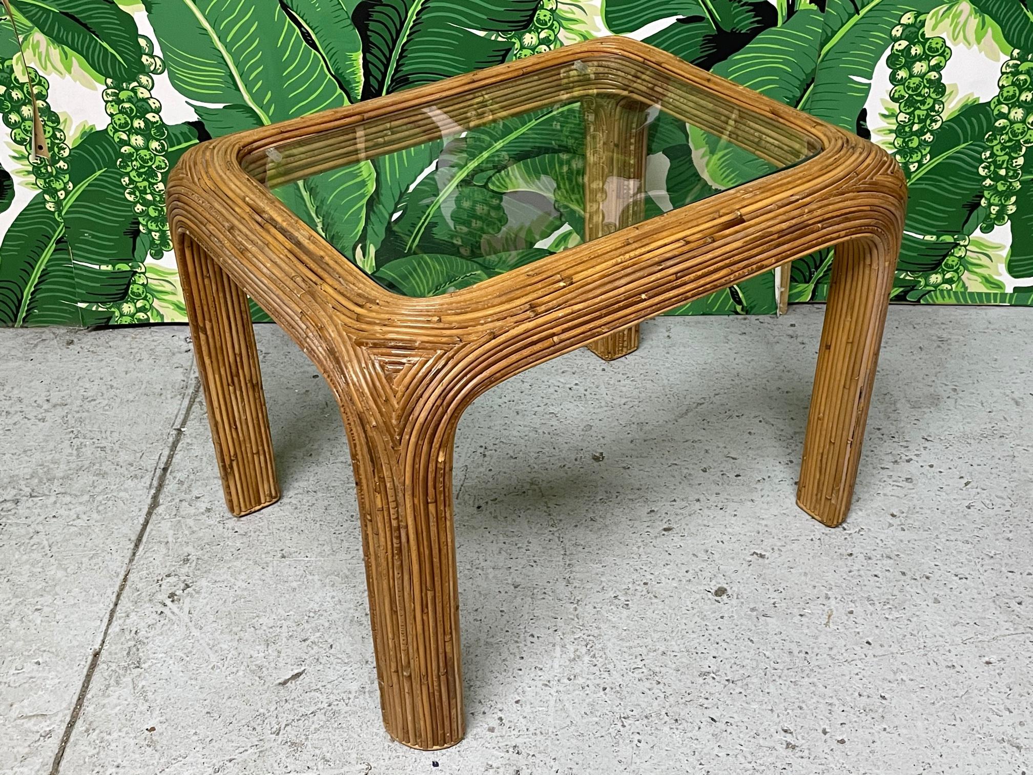 Vintage rattan end table features full veneer of pencil reed rattan and a glass top. Very good condition with minor imperfections consistent with age.