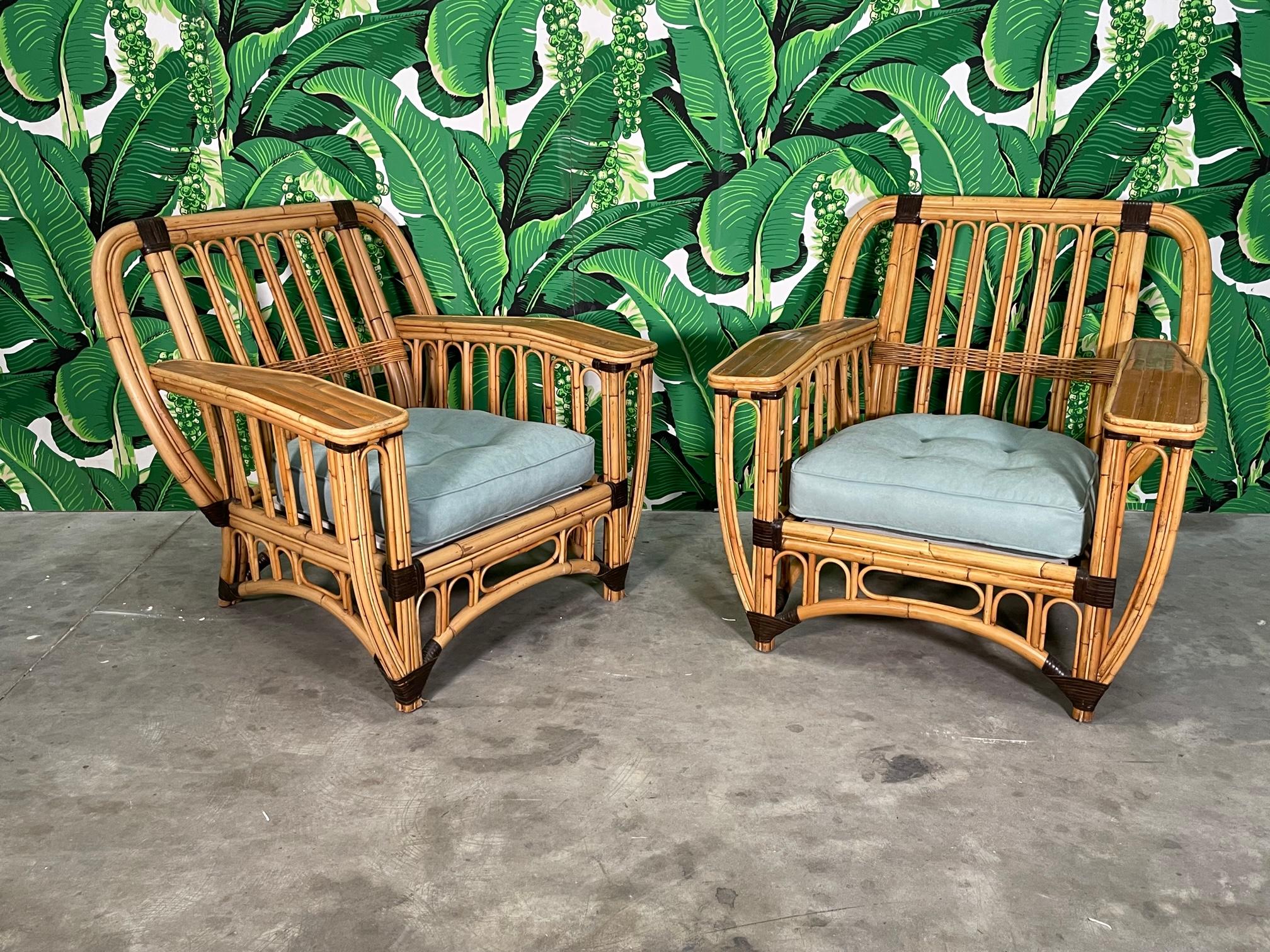 Pair of large rattan club chairs feature two tone design and split reed veneered arms. Extremely comfortable. Good condition with imperfections consistent with age. May exhibit scuffs, marks, or wear, see photos for details. We also have matching