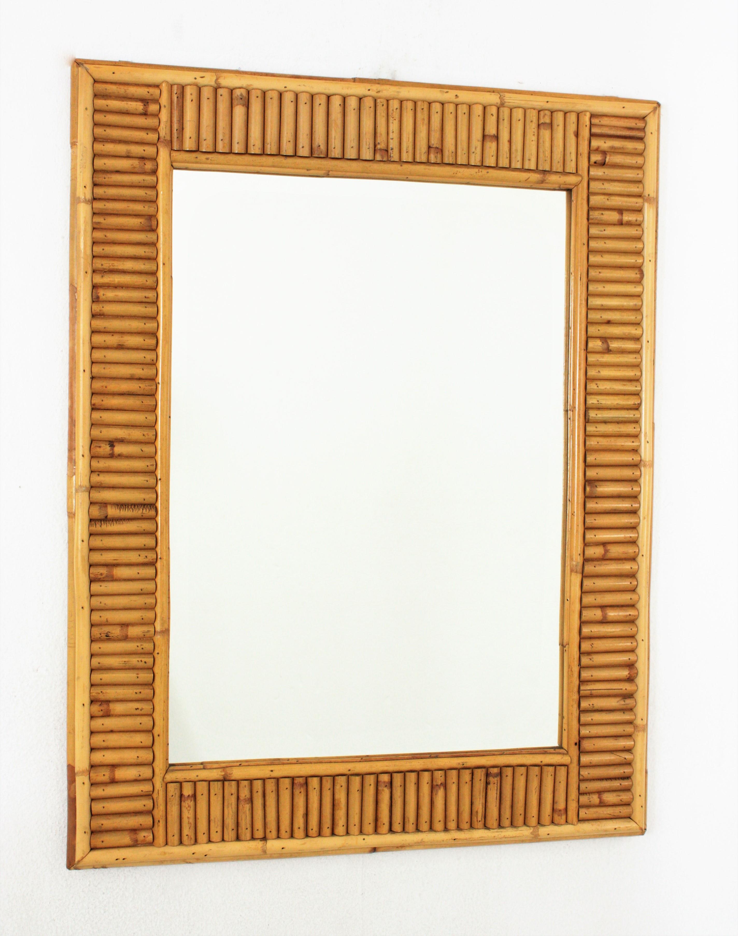 Italienischer Designer Midentury Wandspiegel, gespaltenes Schilf, Bambus, Rattan, Italien, 1960er Jahre.
Dieser coole rechteckige Spiegel wurde in Handarbeit aus Bambusrohr und Rattan hergestellt. Sein Design kombiniert Midcentury- und orientalische