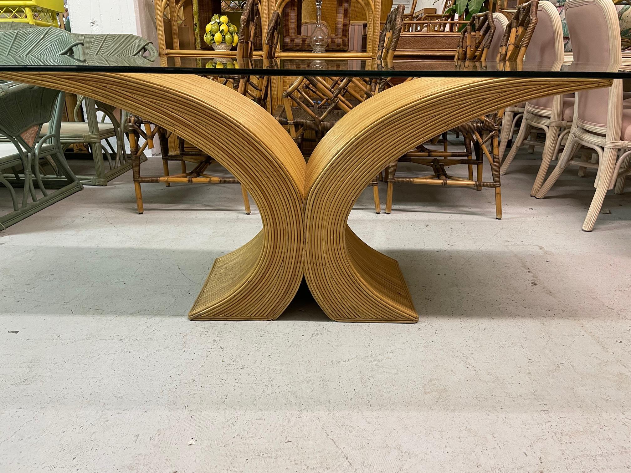 Large sculptural dining table base features full veneer of pencil reed rattan. No glass included. Good condition with minor imperfections consistent with age. May exhibit scuffs, marks, or wear, see photos for details. Base measures 60
