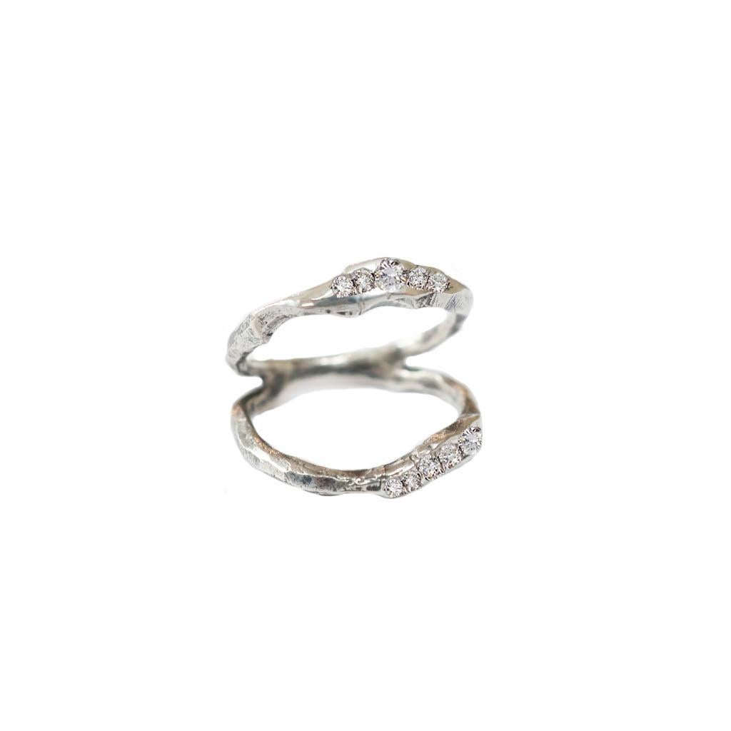 A hand carved asymmetrical split band ring accented with bead set vs white diamonds in 18 karat white gold.  Inspired by the ebbing tide and texture of the water's surface. All diamonds are vs quality and range in size from 1.3-2mm. 
Each piece is