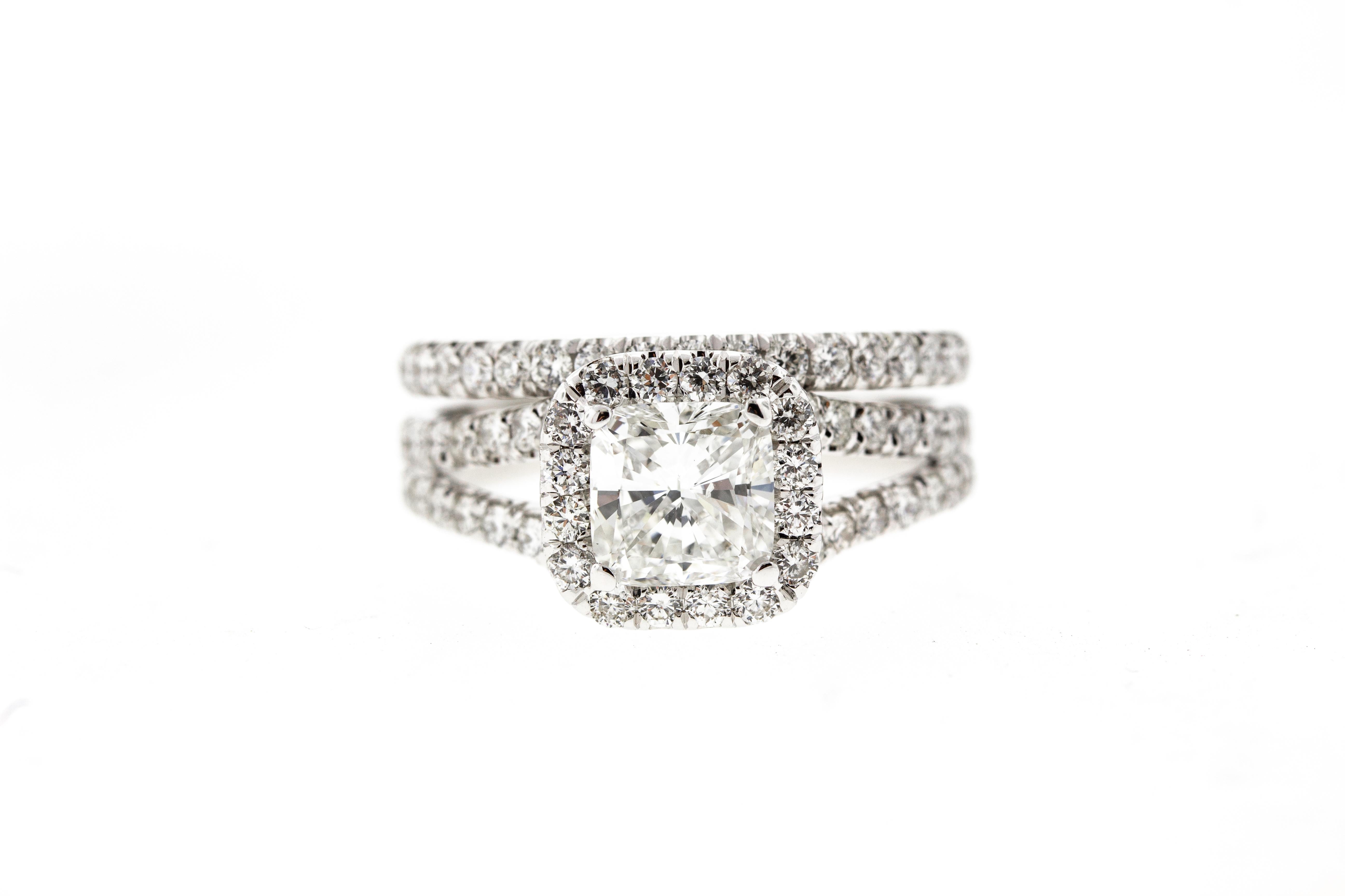 This Split Shank Cushion Diamond Engagement Ring with Diamond Pave is crafted in 18KT white gold, and contains a Cushion Cut Diamond (1.00 carat, D color, SI1 clarity) surrounded by 65 Baguette Cut Diamonds (0.75 total carat weight, F color, VS