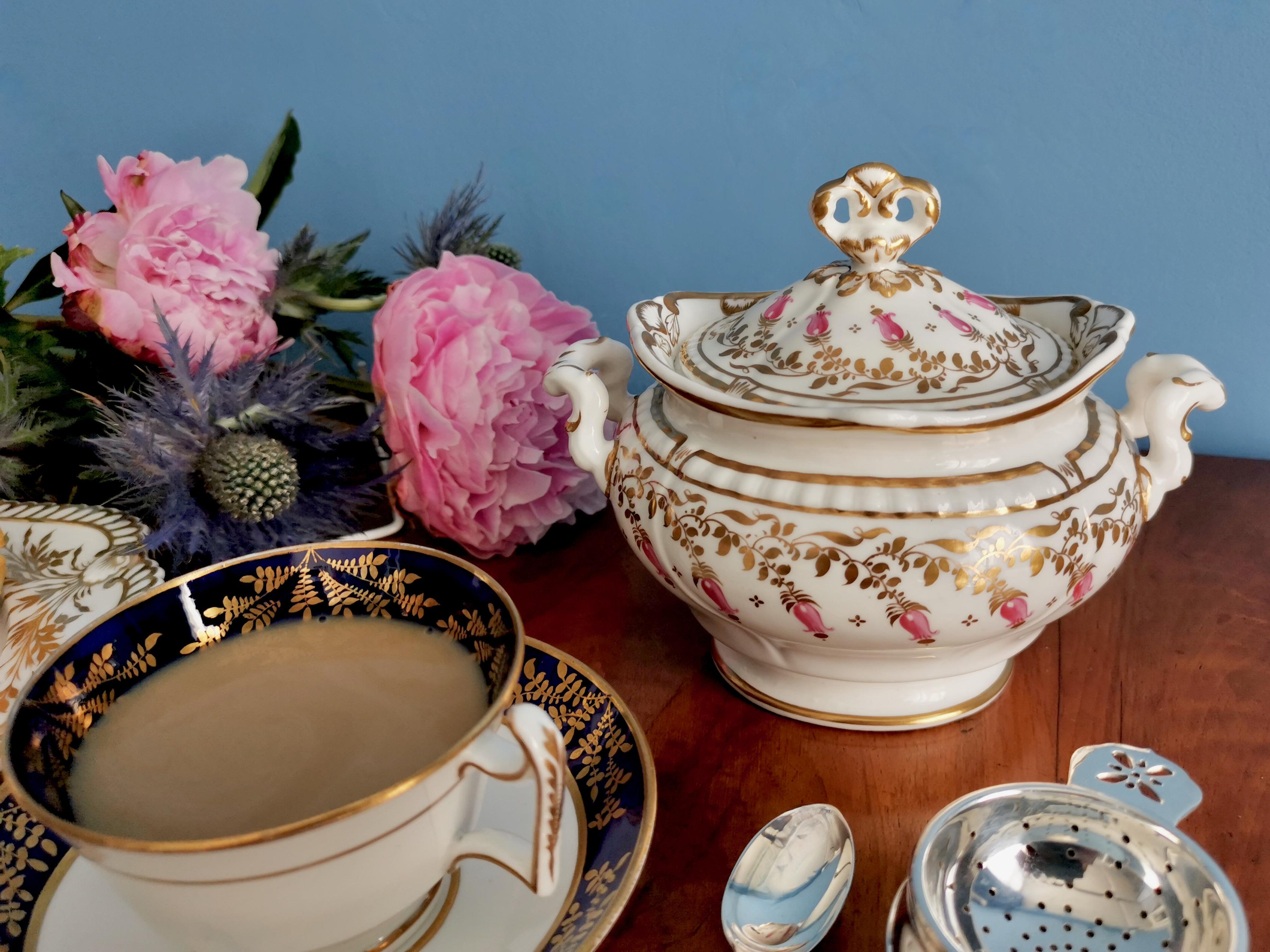 This is a beautiful lidded sucrier made by Spode in or shortly after 1828. The sucrier is made in Felspar porcelain and has a beautifully moulded shape with a crown-like shaped finial. It is decorated in a pink and gilt harebell pattern.
 
Spode